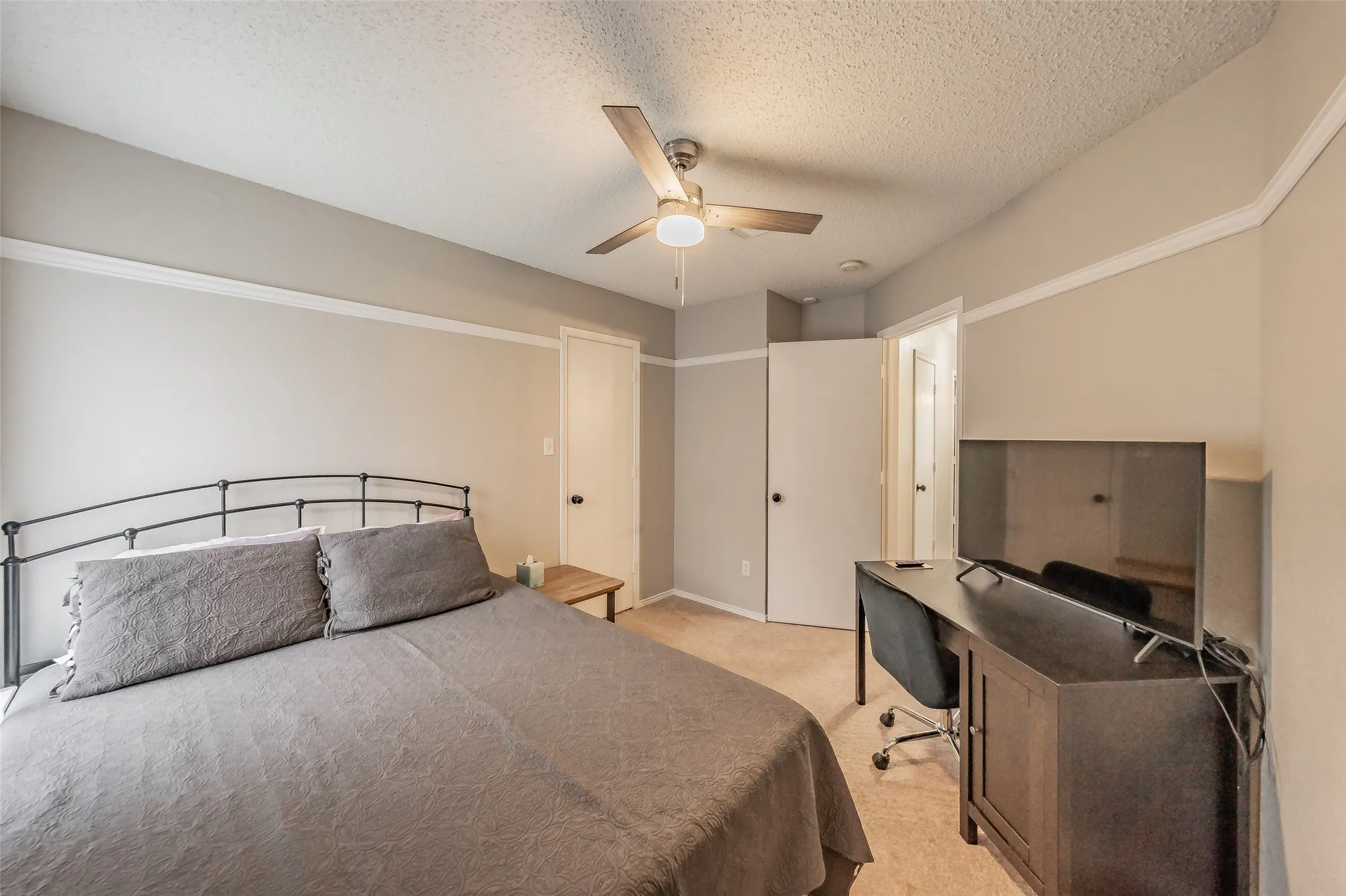 Carpeted room with a ceiling fan