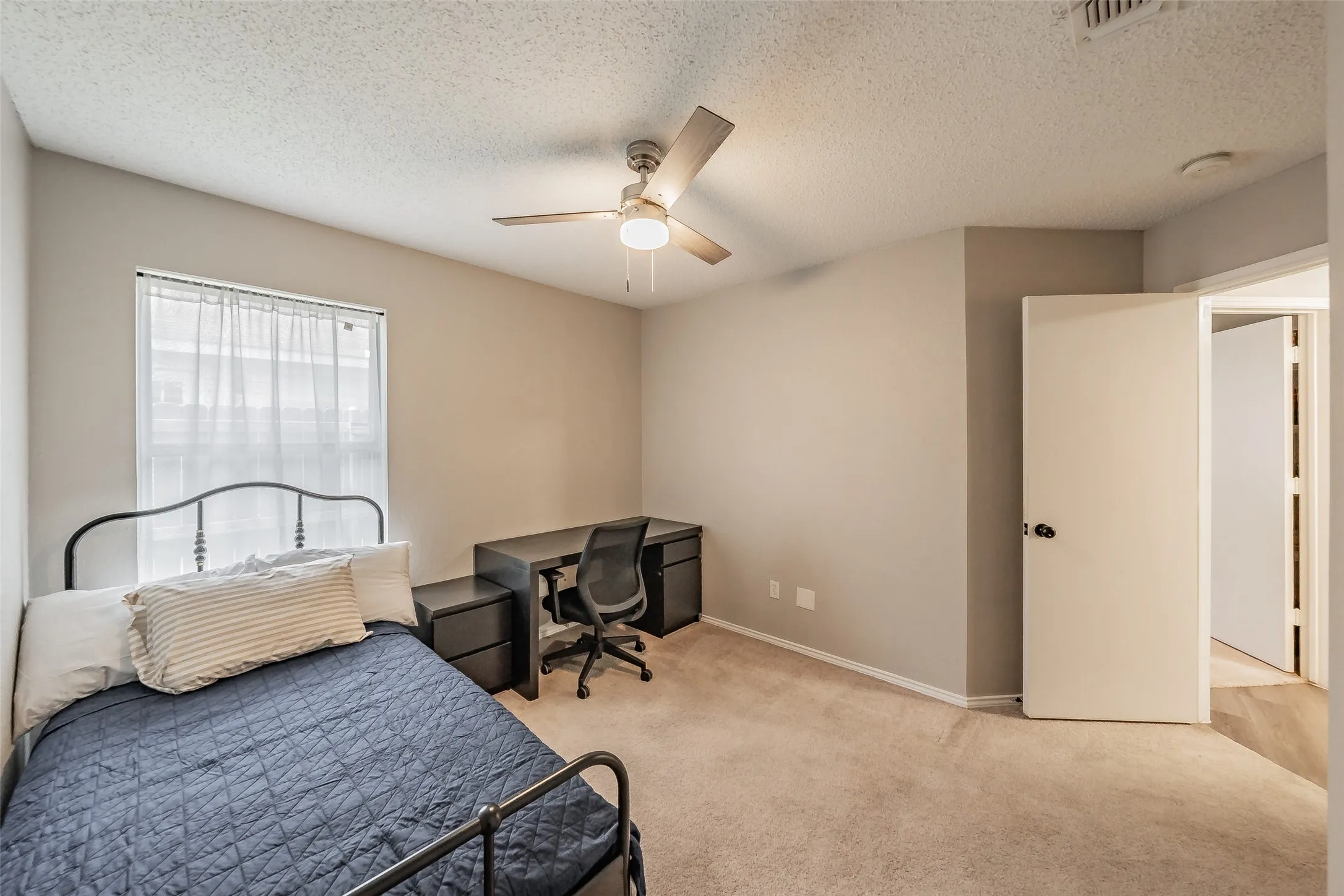 Bedroom featuring neutral wall paint, carpet flooring, a ceiling fan with integrated lighting, and a window with blinds