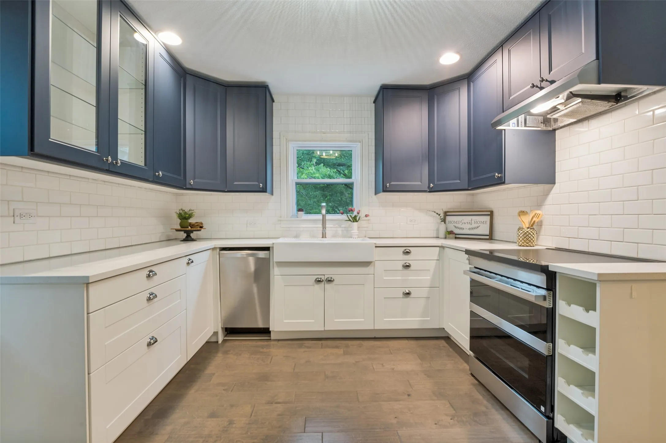 KITCHEN IS FULL OF CHARM WITH NAUTICAL BLUE CABINETS AND BEAUTIFUL COUNTERTOPS
