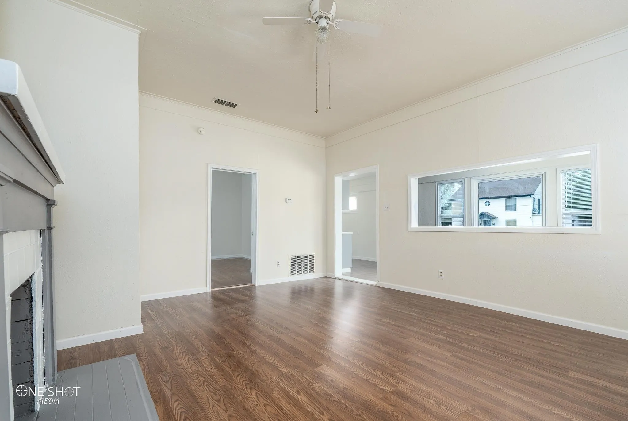 Unfurnished living room with ornamental molding, dark hardwood / wood-style floors, and ceiling fan