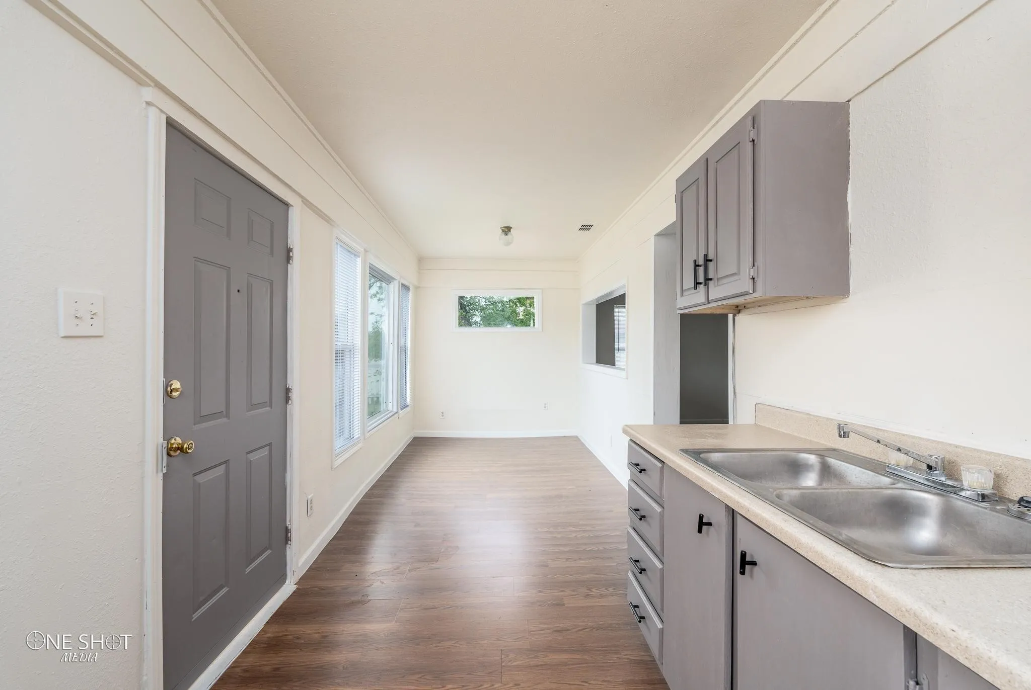 Kitchen featuring dark hardwood / wood-style floors, sink, gray cabinetry, and ornamental molding