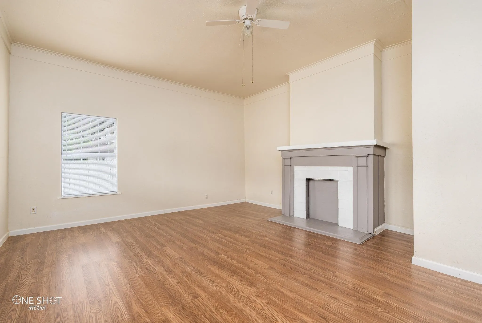 Unfurnished living room with a high end fireplace, ceiling fan, light wood-type flooring, and ornamental molding