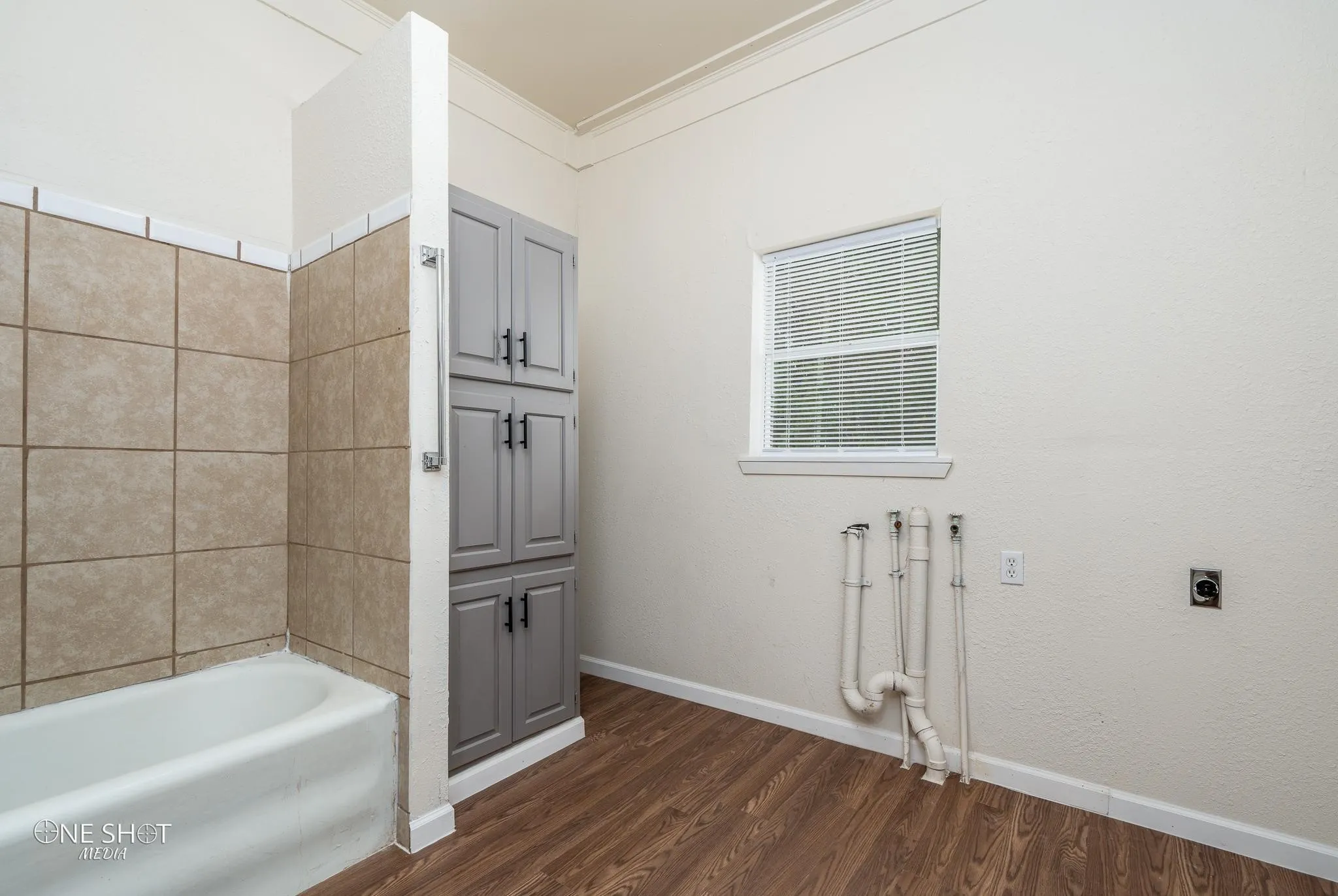 Bathroom featuring  shower combination, crown molding, and wood-type flooring