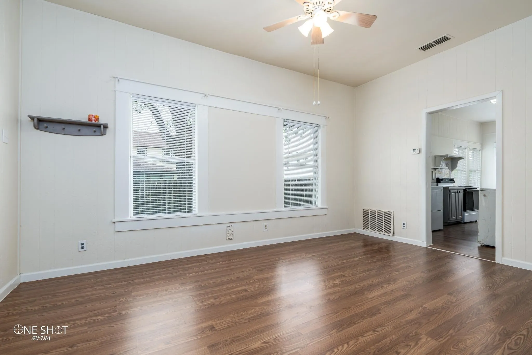Empty room with ceiling fan and dark hardwood / wood-style floors