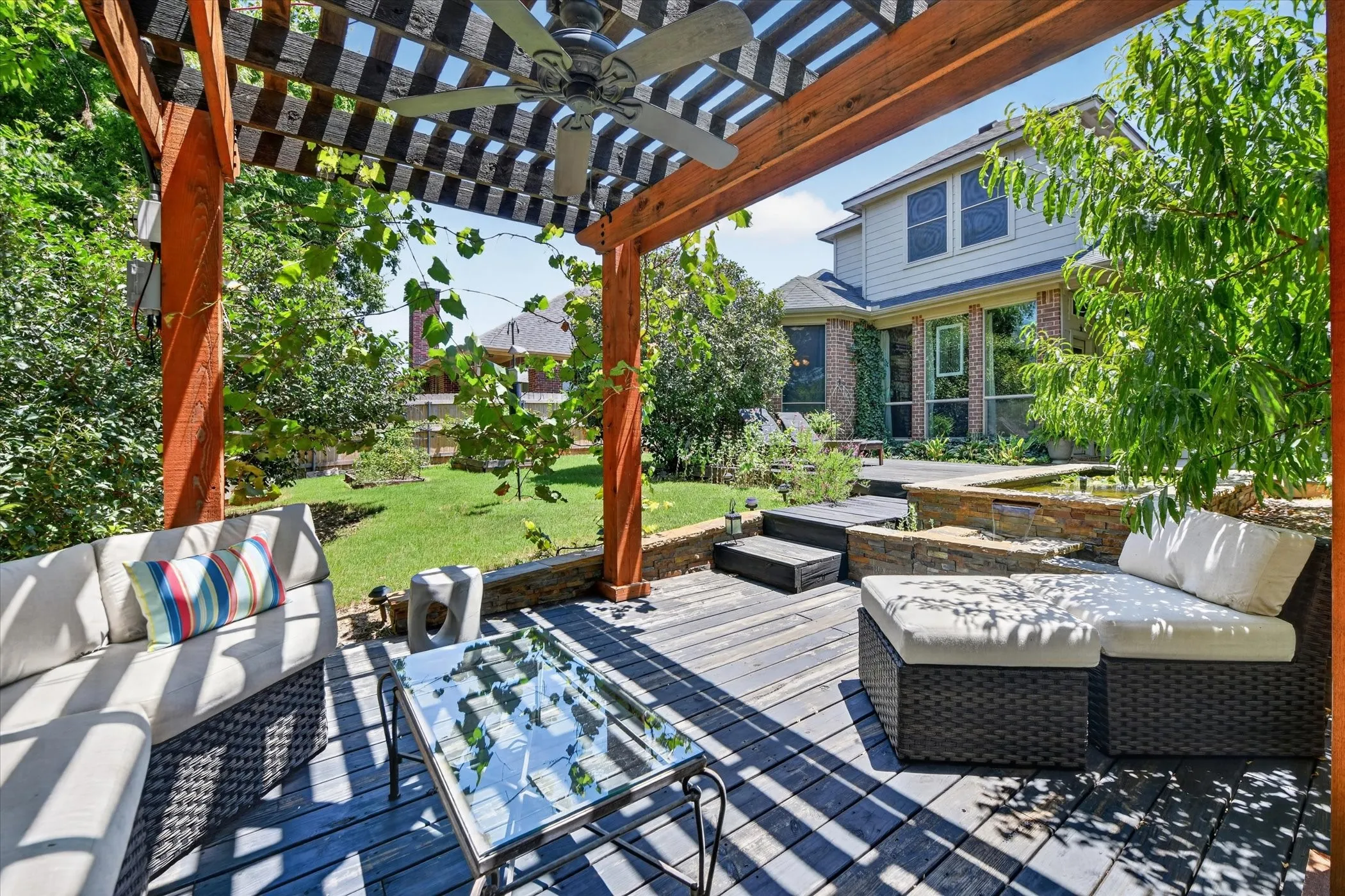 Wood-decked patio with a pergola and ceiling fan