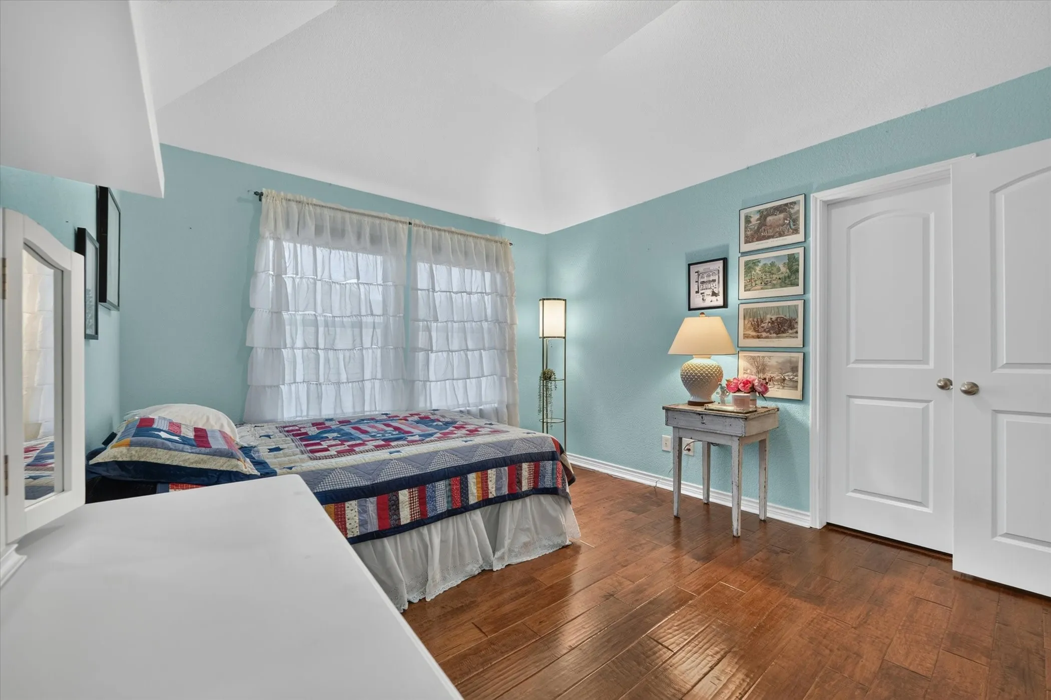 Vaulted ceiling room featuring wood-finish flooring
