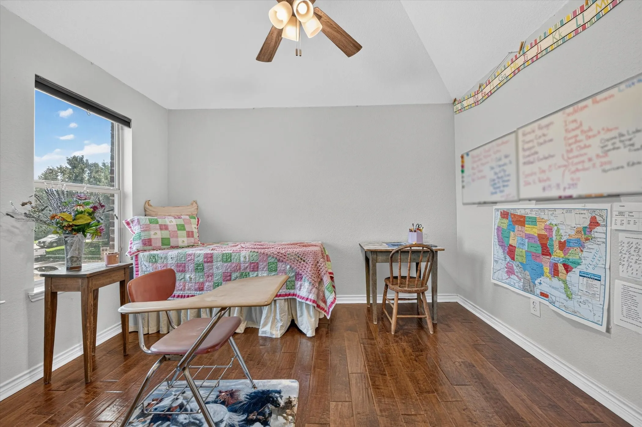 Room featuring wood-finish flooring, light grey walls, and a vaulted ceiling