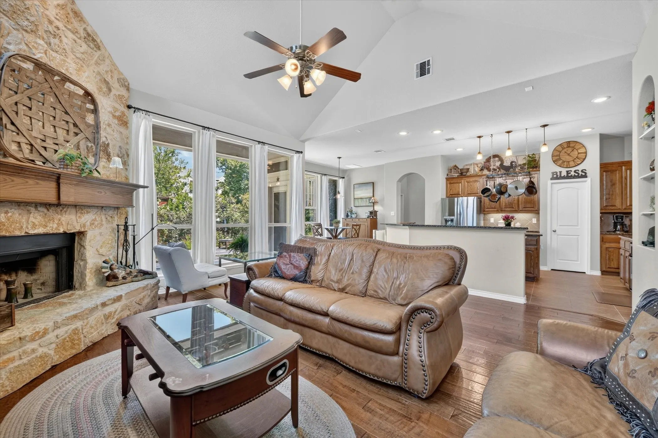 Open-concept living area featuring a vaulted ceiling and wood-finish flooring
