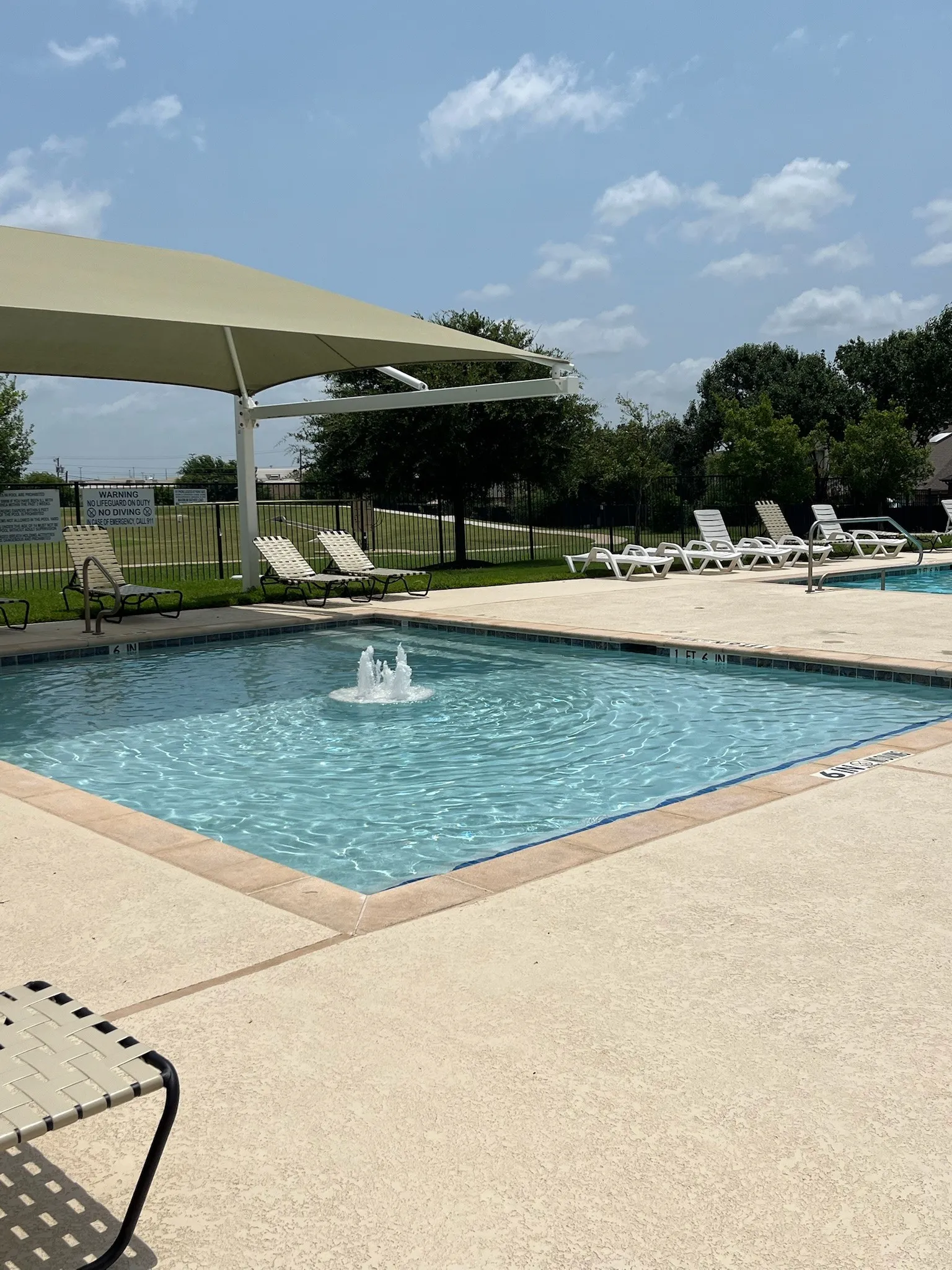 Toddler swimming pool with a fountain feature, surrounded by a concrete deck