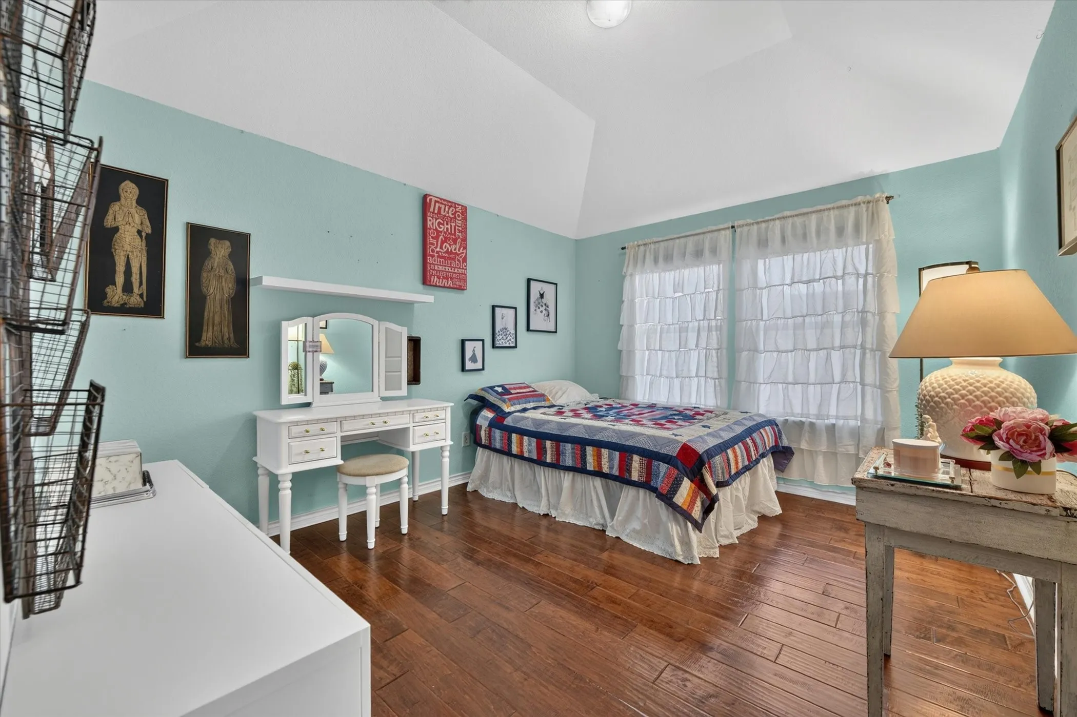 Bedroom featuring wood-finish flooring, vaulted ceiling, and multiple windows