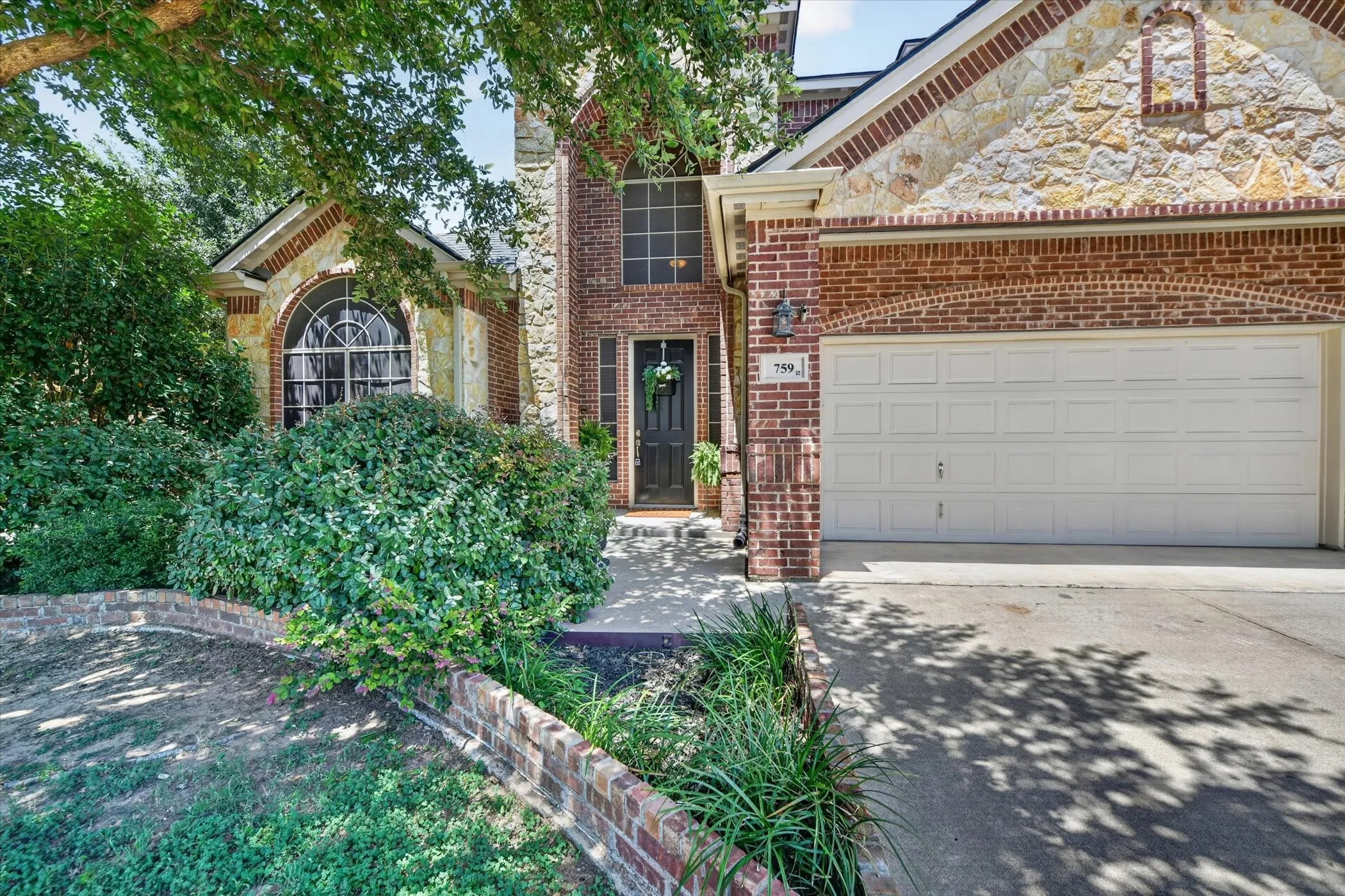 Traditional brick and stone exterior with a two-car garage