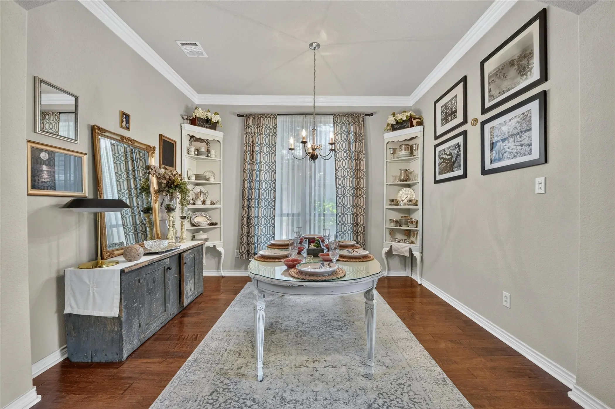 Interior dining space featuring wood-finish flooring, light grey wall paint, and white crown molding