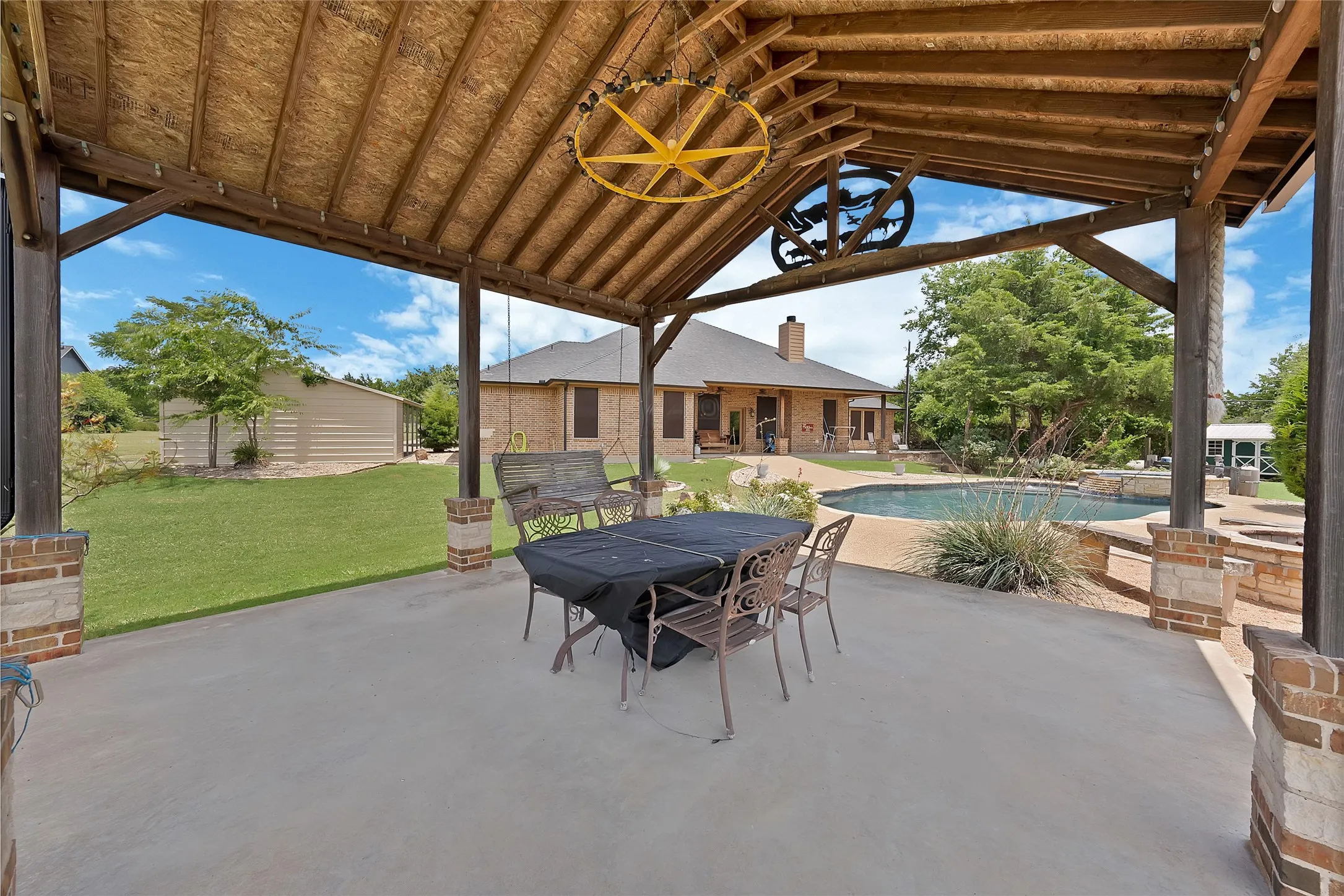 Pergola outdoor living space off the pool with view of the arena