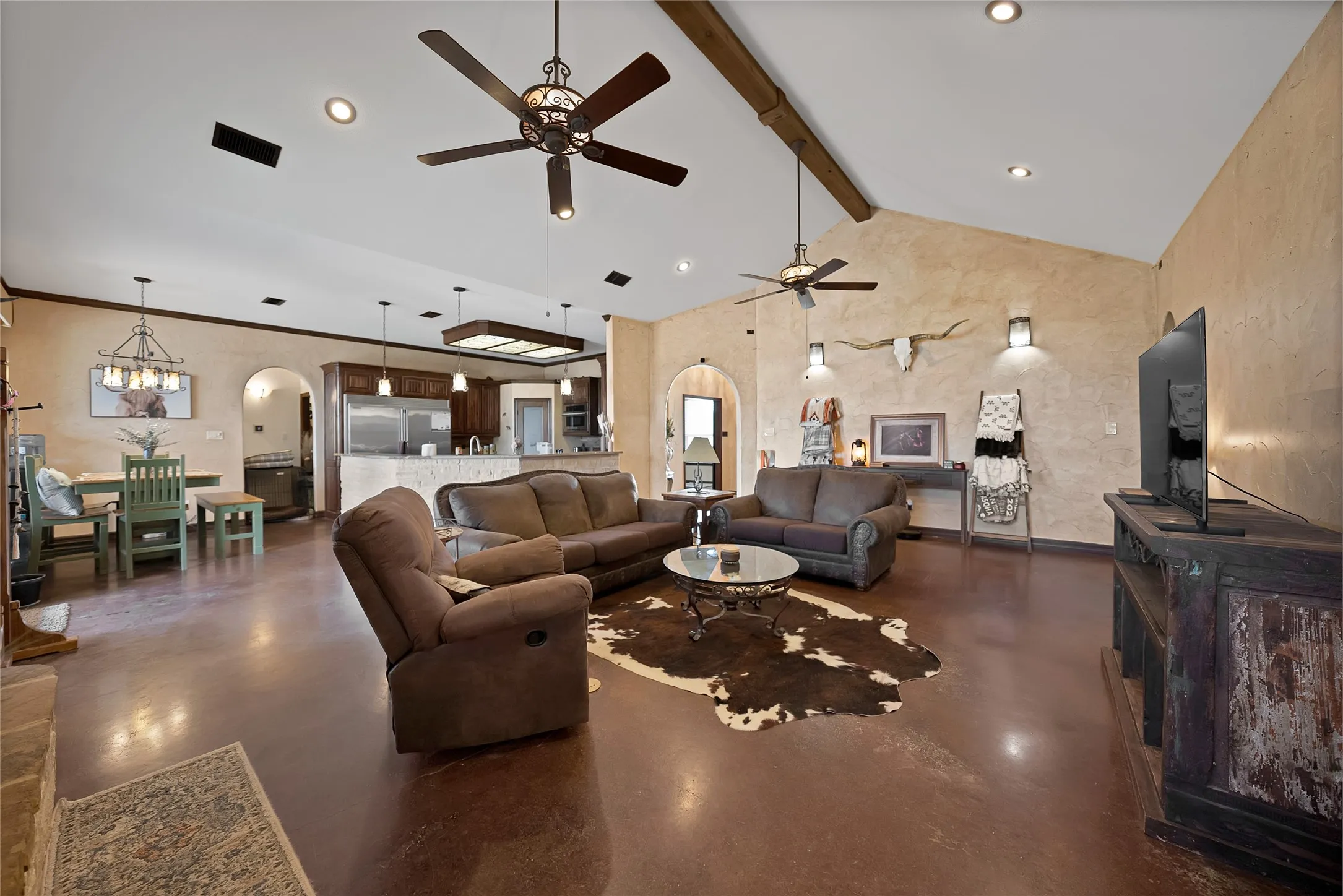 Beam and stunning wall to wall custom handcrafted stained concrete floors in a rich color with artisan character brings ranch & luxury together