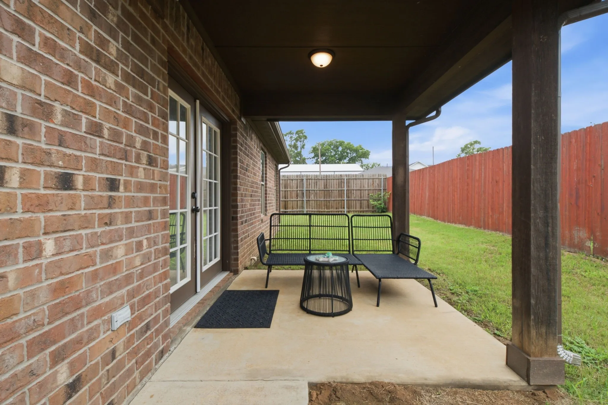 Covered patio offering the perfect spot for morning coffee, outdoor dining, or relaxing while overlooking the backyard.
