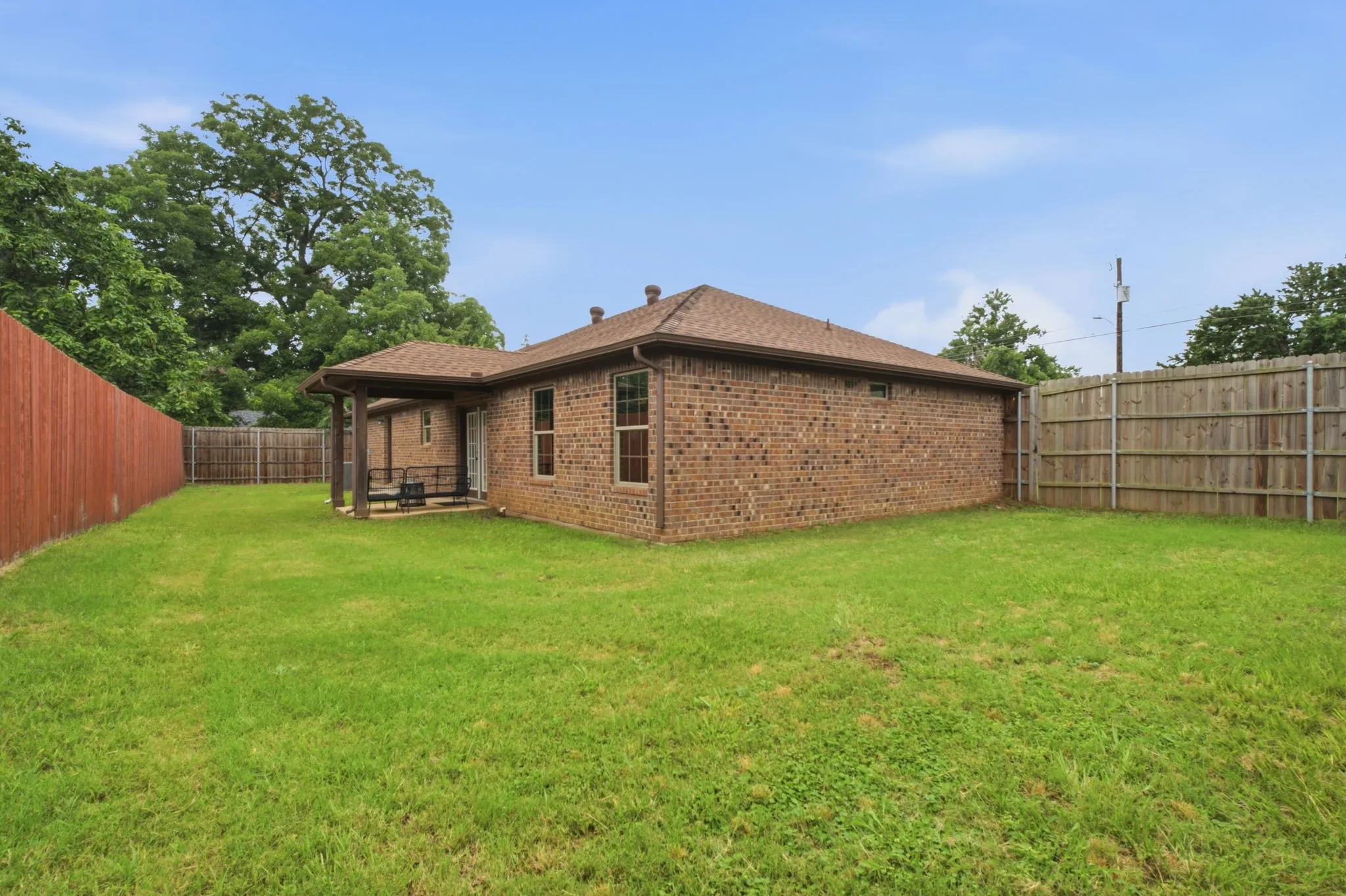 Expansive backyard enclosed by an 8-foot privacy fence, providing space for pets, play, gardening, or future outdoor improvements.