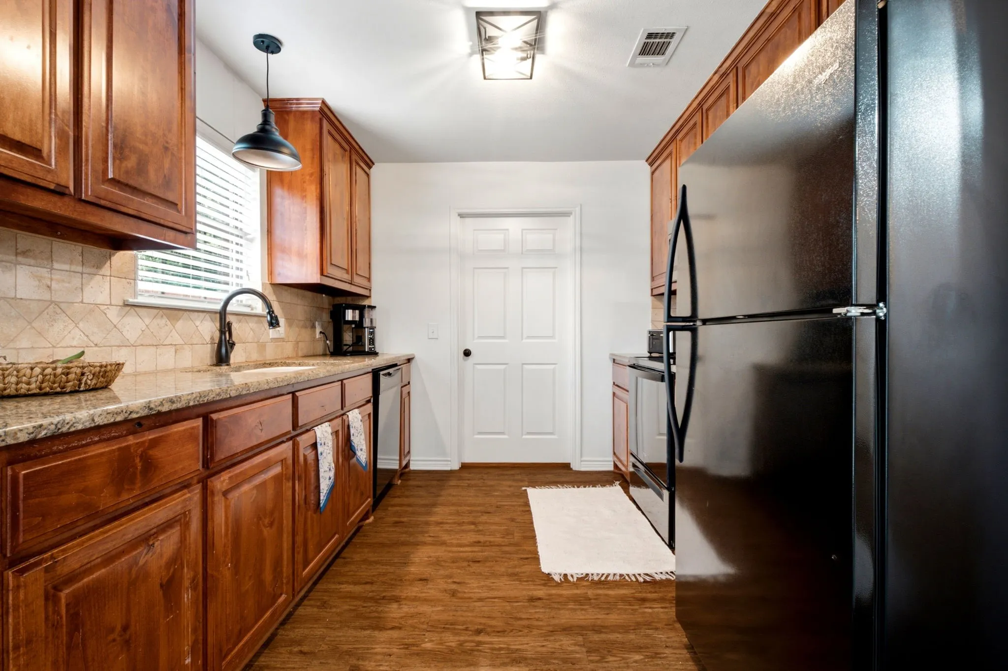 Functional galley-style kitchen offers extensive counter space and custom cabinetry with soft-close hinges.