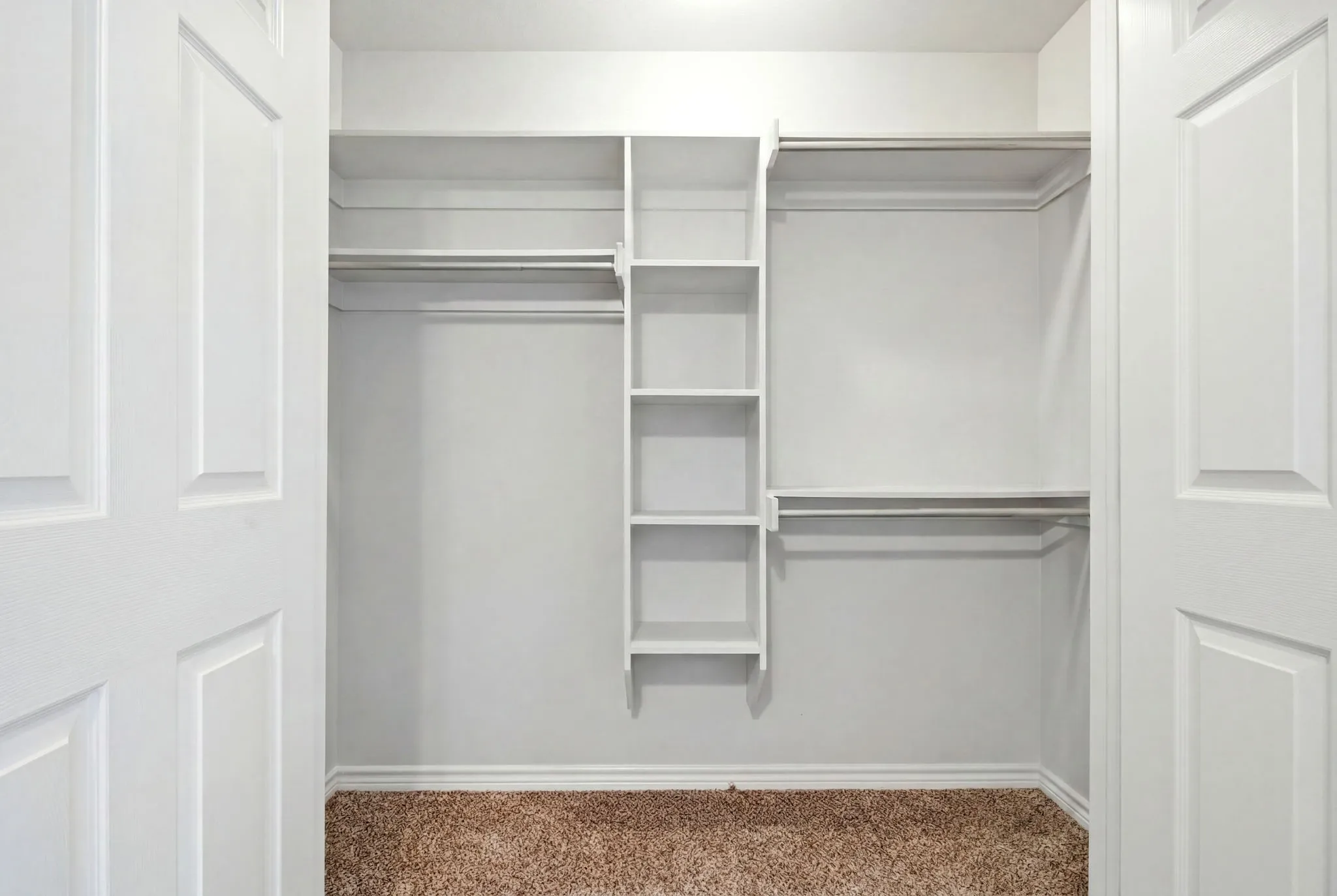 Oversized closet with built-in shelving, dual hanging areas, and excellent storage solutions.
