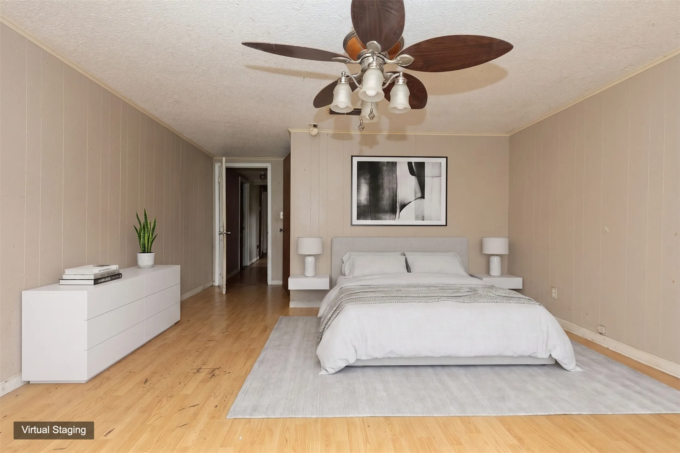 Spacious interior featuring wood-finish flooring, vertical paneling, and a ceiling fan with integrated lighting