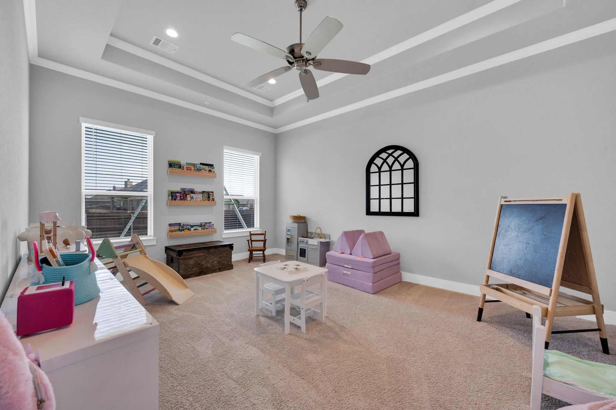 Spacious game room or additional bedroom featuring vaulted ceilings, a large window with white blinds, neutral carpeting, and light gray wall paint
