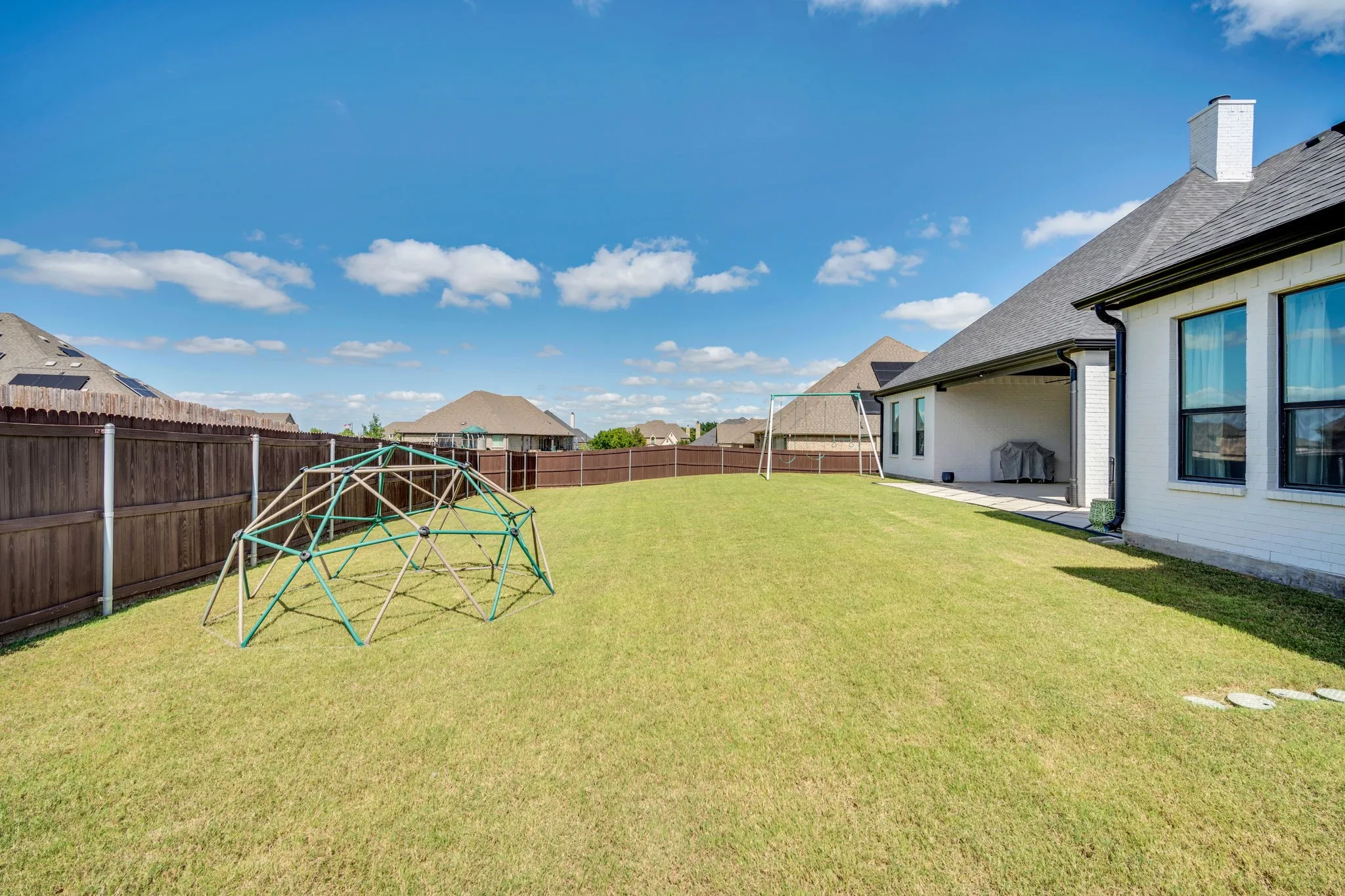Expansive green lawn with a full wood privacy fence