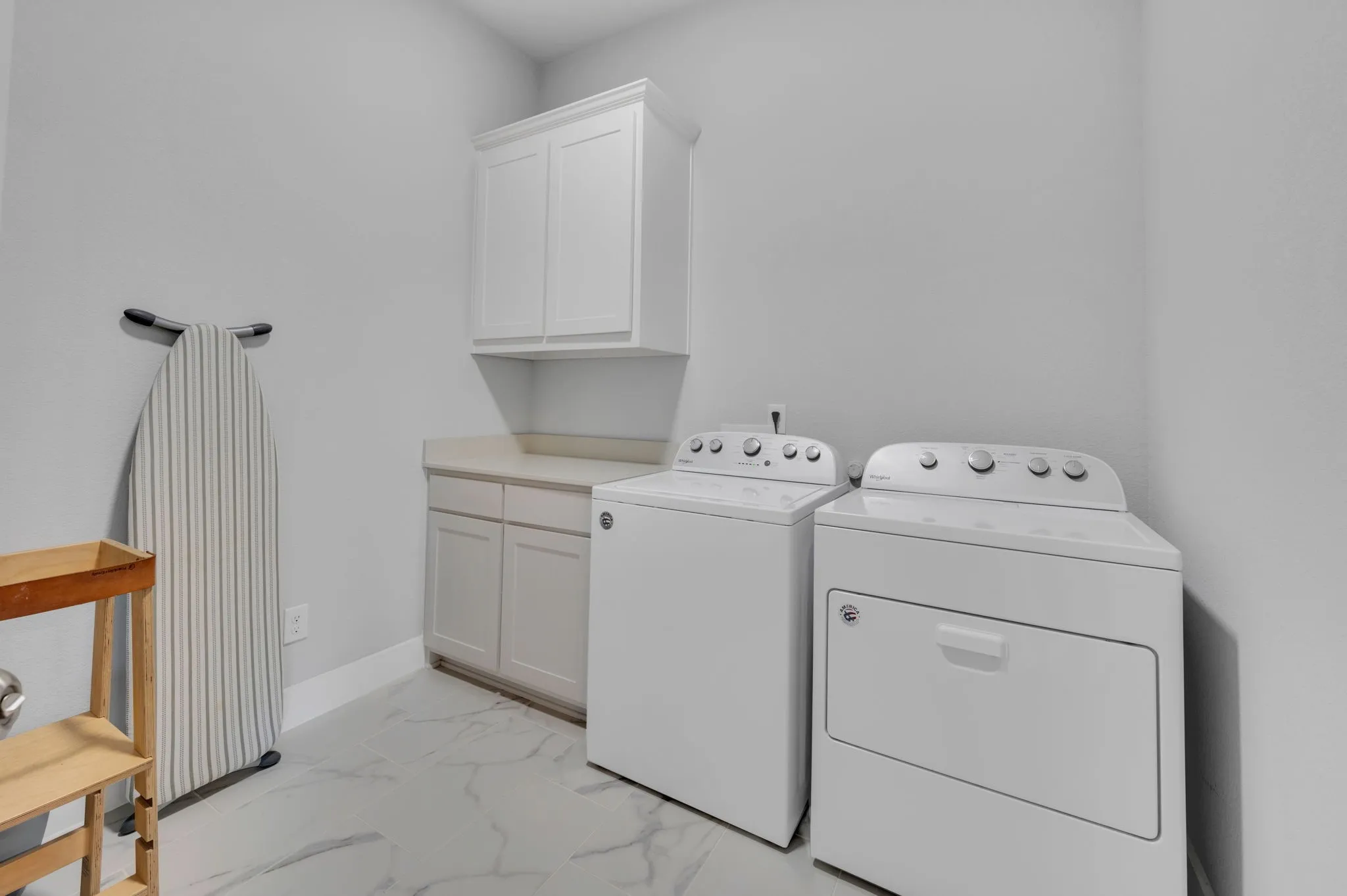 Spacious bathroom featuring a freestanding tub, separate glass-enclosed shower with subway tile, dual vanity countertops, and large format marble-look floor tiles