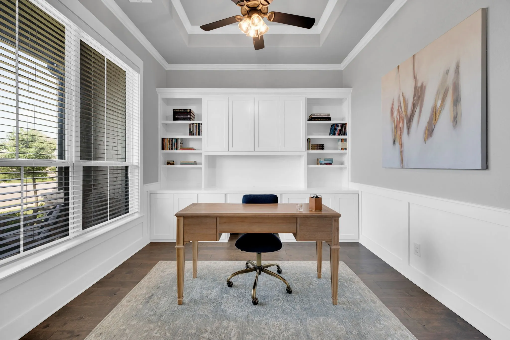 Wood-finish flooring anchors this space featuring extensive built-in cabinetry and shelving