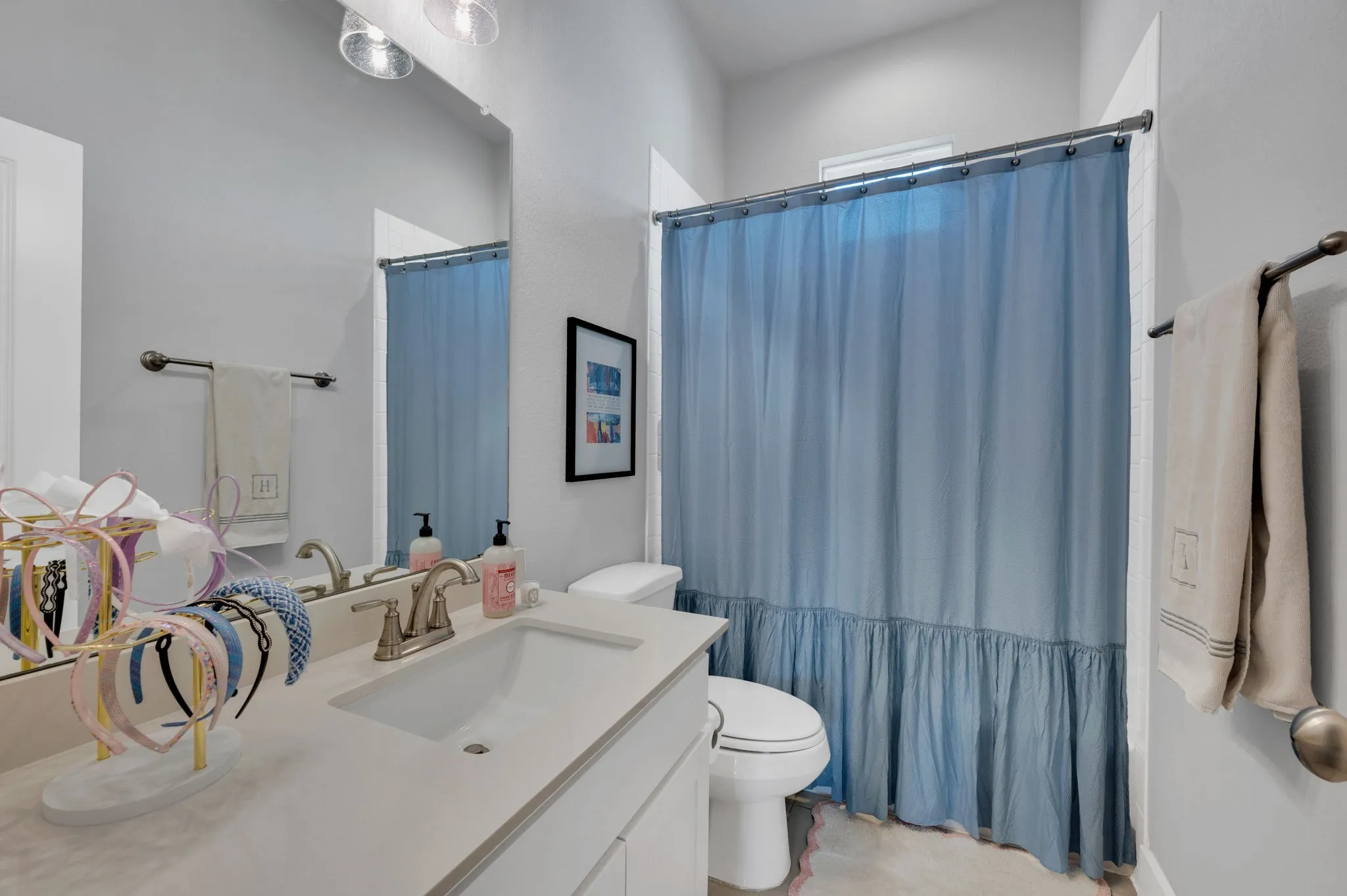Carpeted interior room featuring a window with horizontal blinds, a ceiling fan with integrated lighting, and light gray wall paint