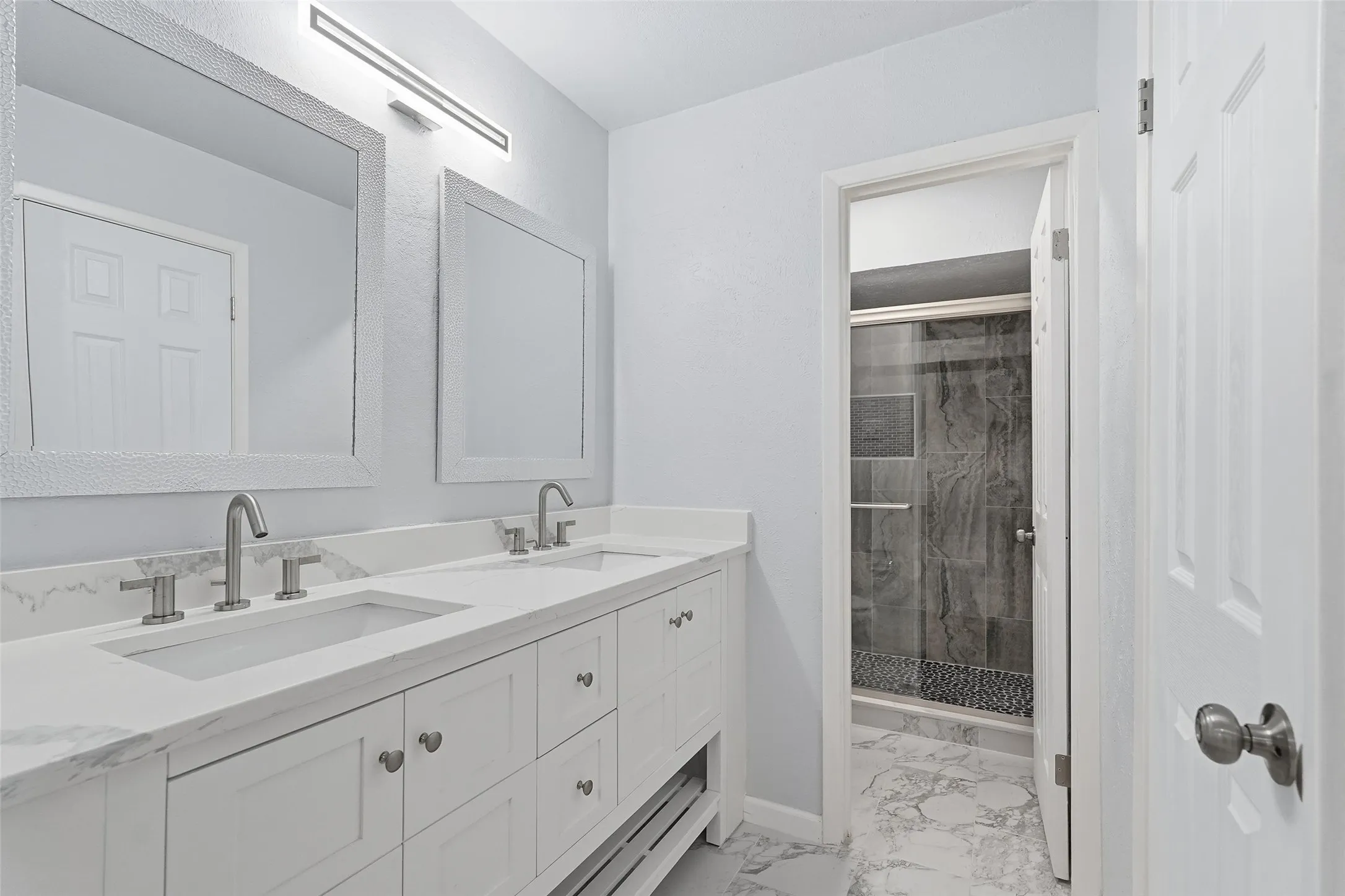 Double vanity with white cabinetry and integrated sinks, complemented by brushed nickel fixtures