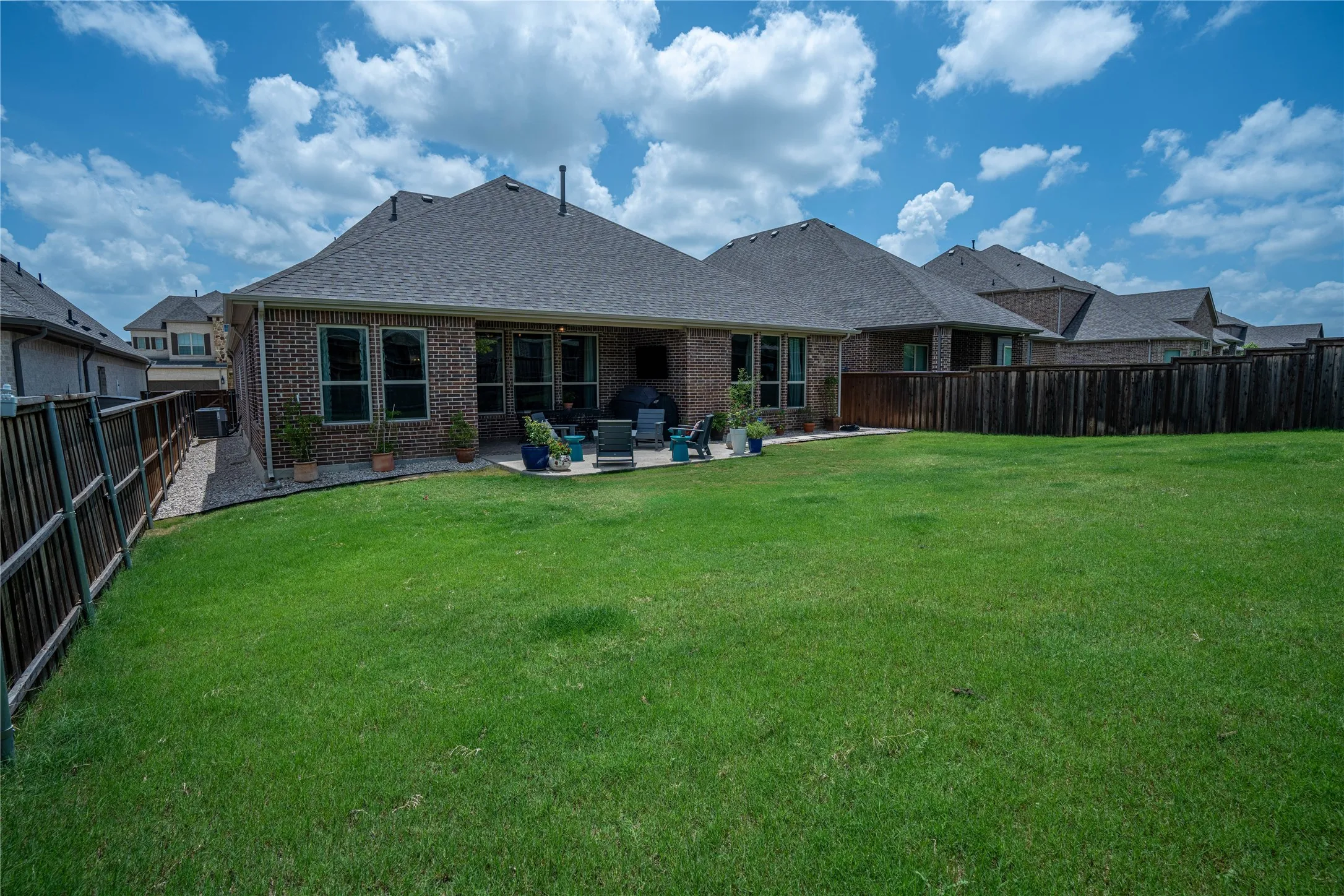 Expansive green lawn with a privacy fence