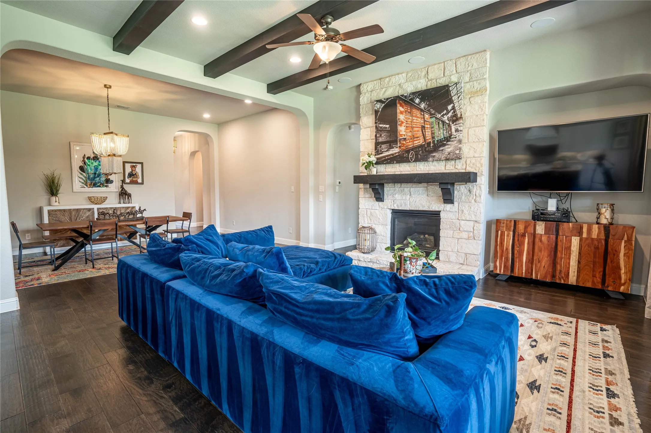 Spacious living area featuring exposed wood beams, wood-finish flooring, and recessed lighting