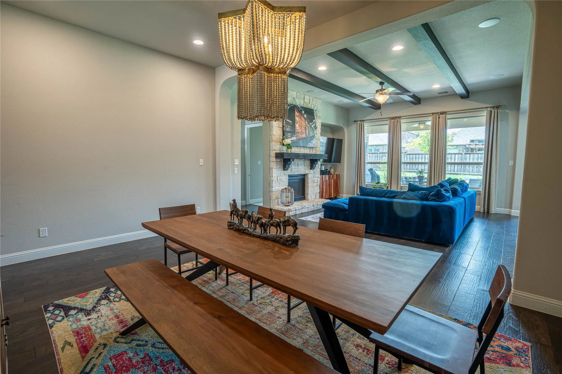 Open-concept dining area featuring dark wood-finish flooring and a decorative beaded chandelier