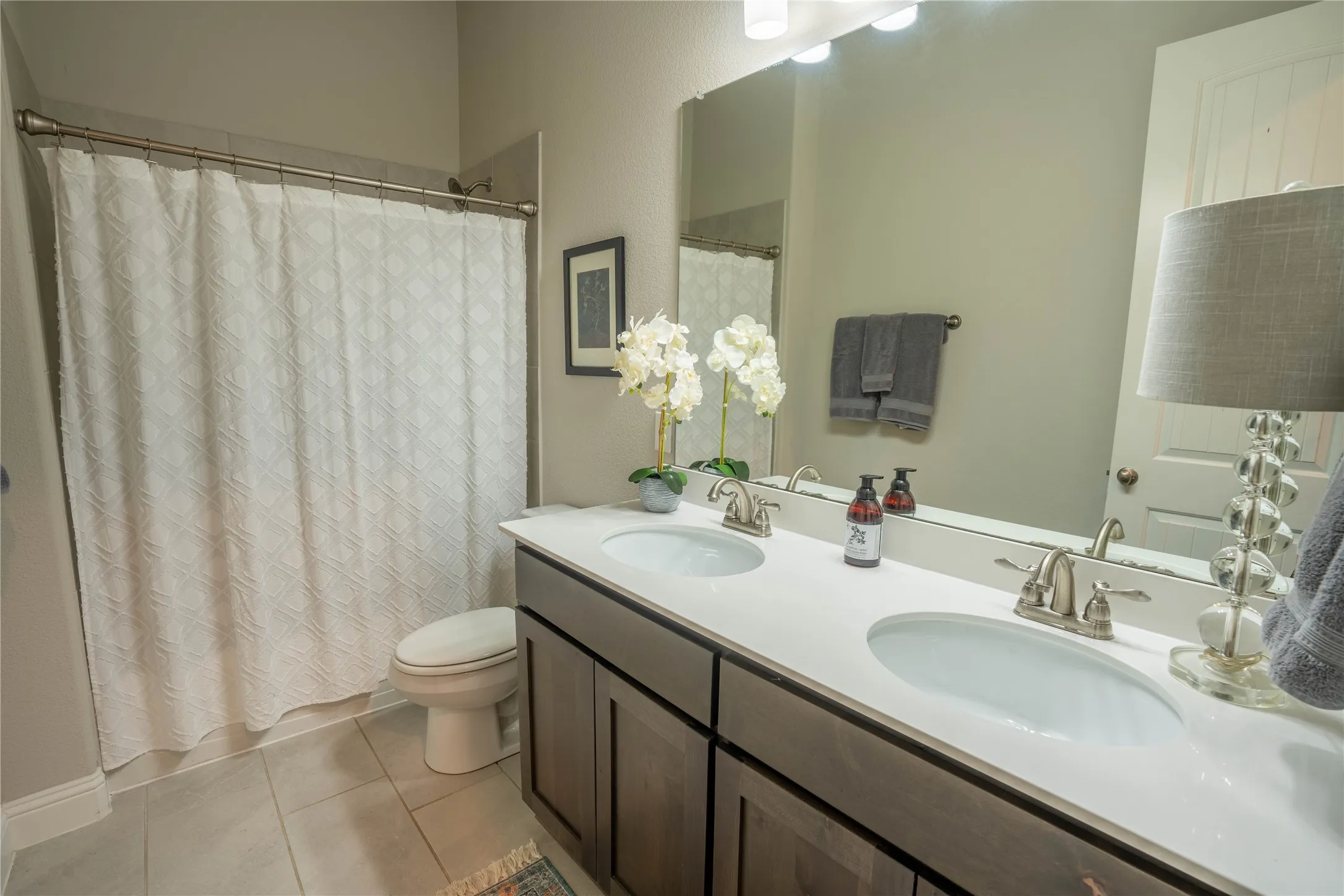 Double vanity with undermount sinks, brushed nickel fixtures, and a large mirror
