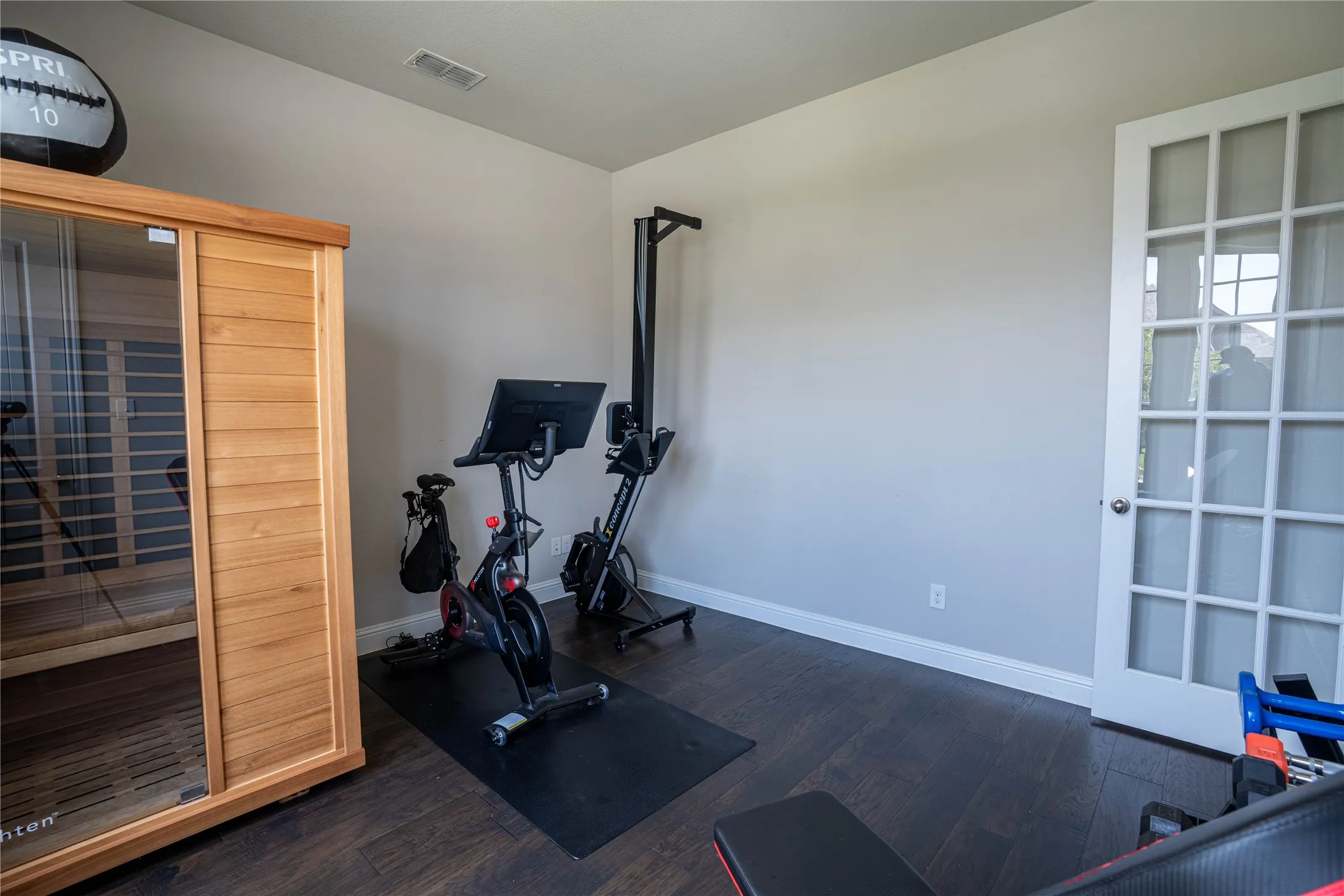 Dedicated interior space featuring dark wood-finish flooring and a white French door with glass panels
