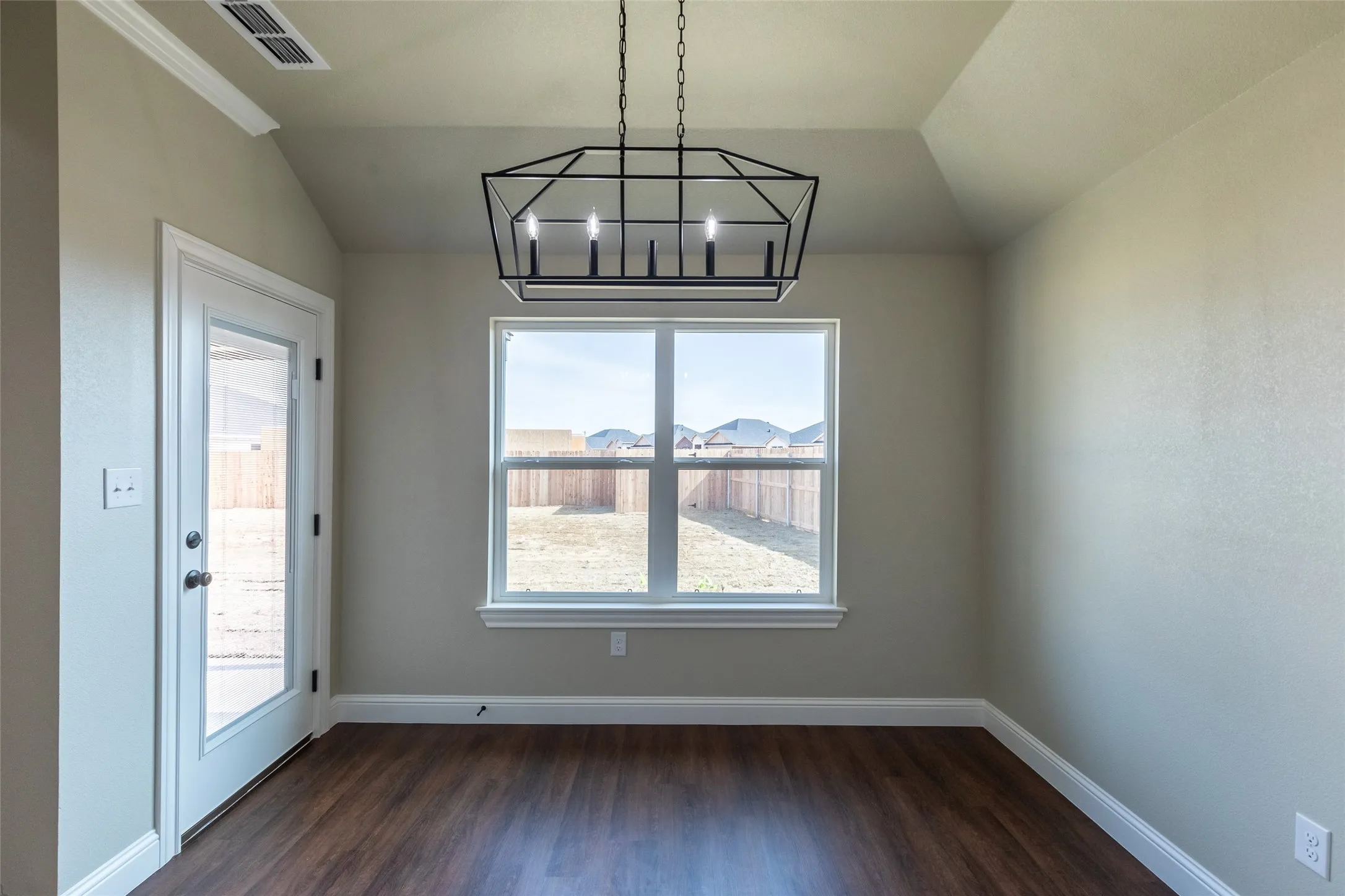 Interior space featuring wood-finish flooring, a contemporary geometric chandelier, and a tray ceiling