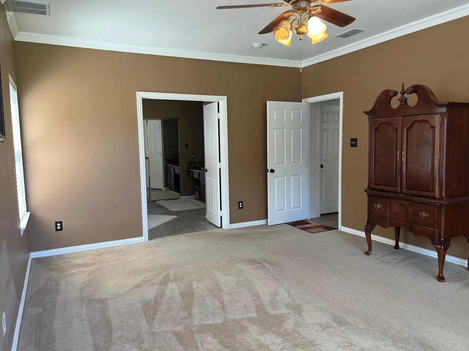 Spacious room featuring neutral carpeting and warm-toned walls