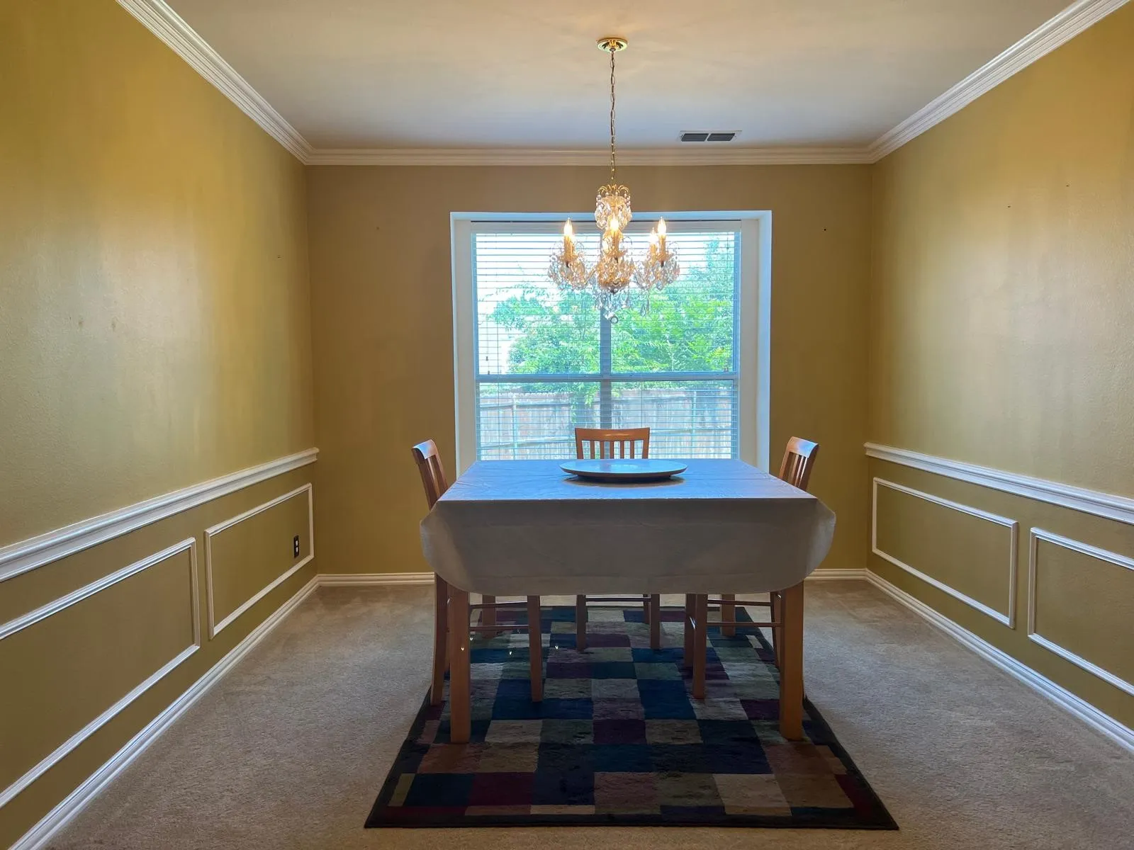 Formal dining space featuring crown molding, wainscoting, and a crystal chandelier