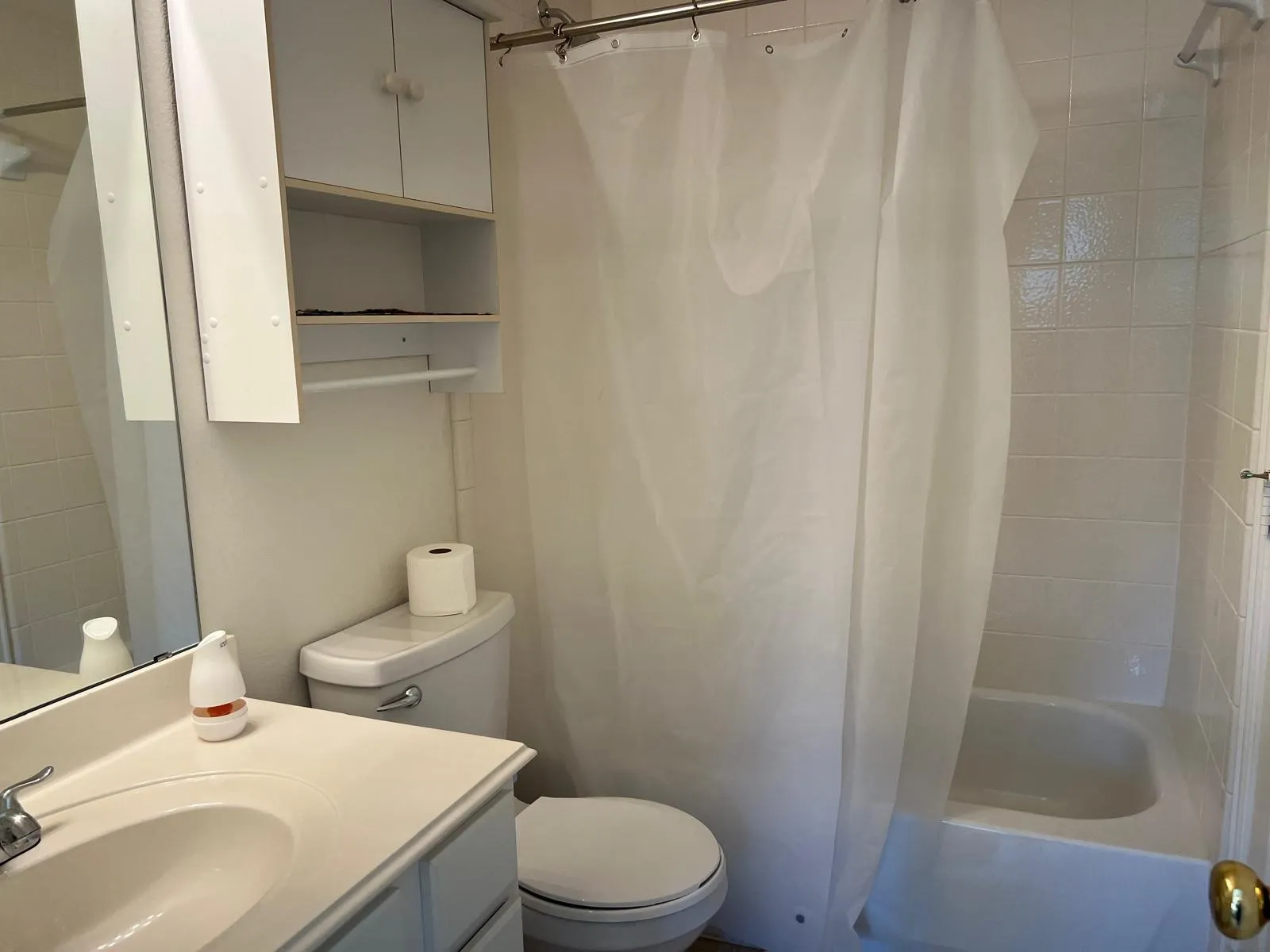 Bathroom featuring a single vanity, integrated sink, and white cabinetry