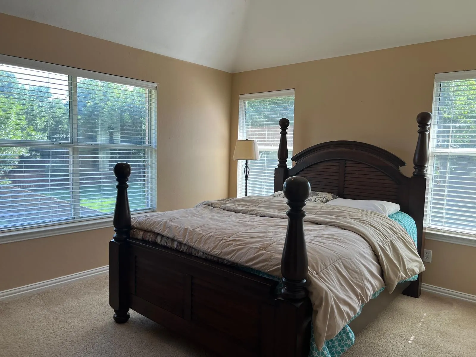 Bedroom featuring vaulted ceilings, neutral-toned walls, and carpet flooring