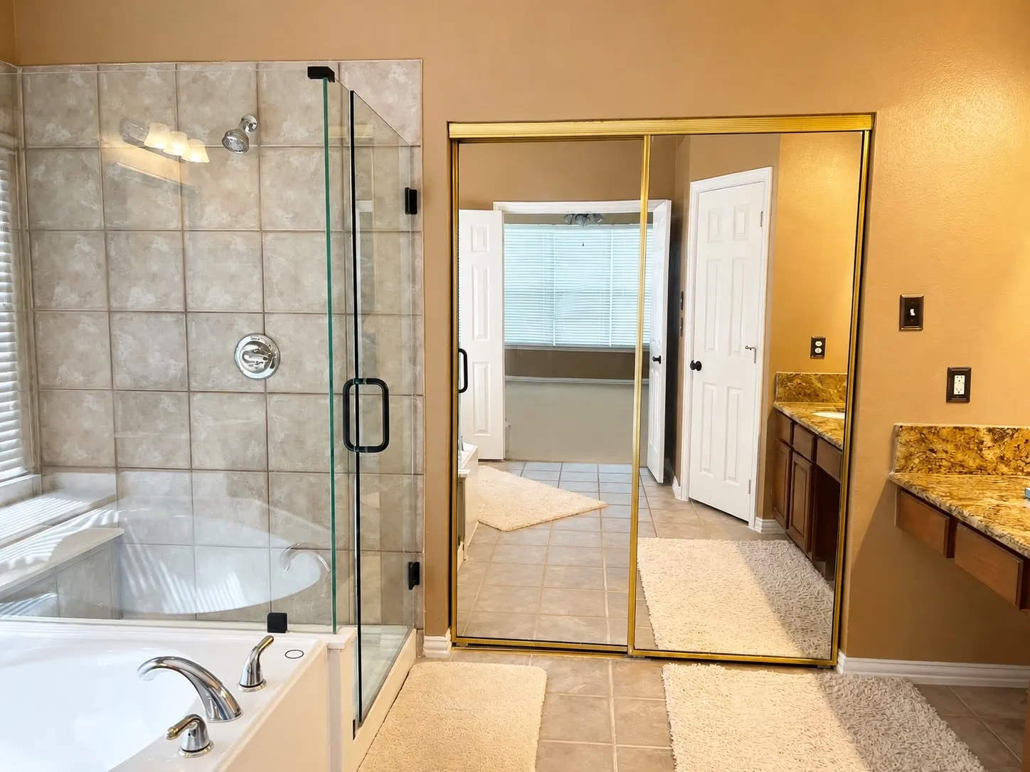 Bathroom featuring a glass-enclosed shower, a built-in bathtub with chrome fixtures, tile flooring, and mirrored closet doors