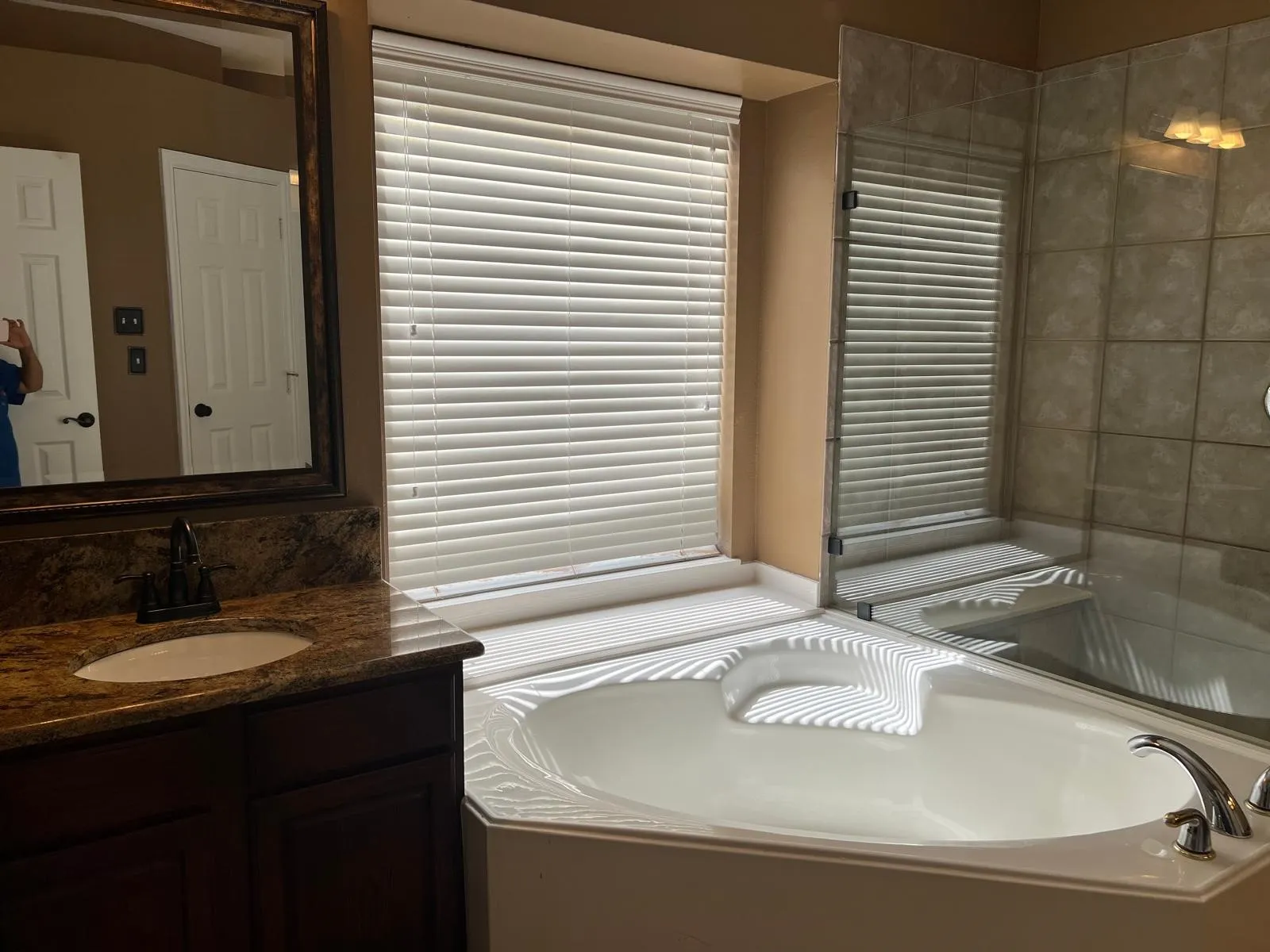 Alcove bathtub with white tile surround and integrated glass-enclosed shower