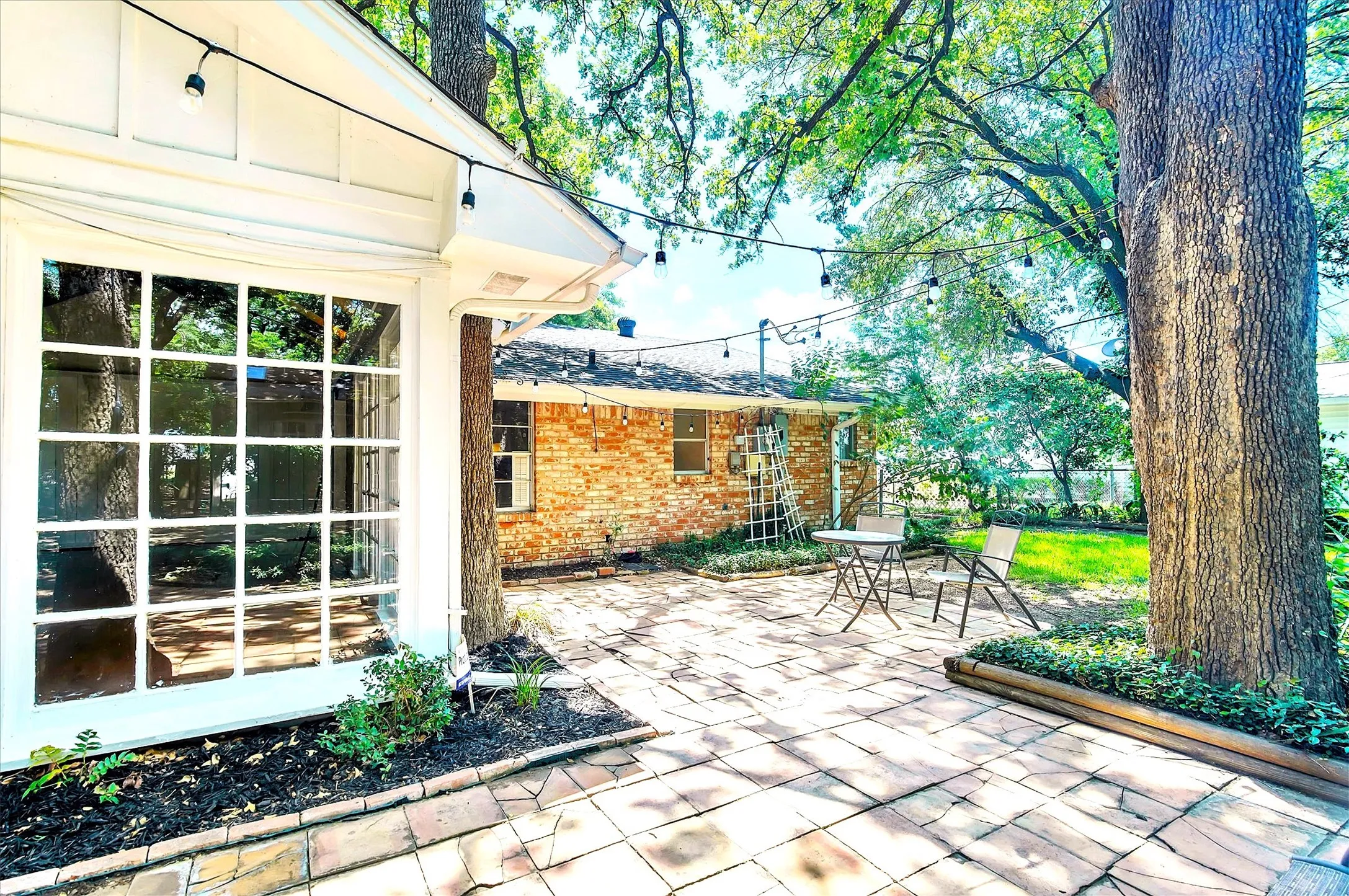 Paved patio area featuring brick-patterned hardscaping