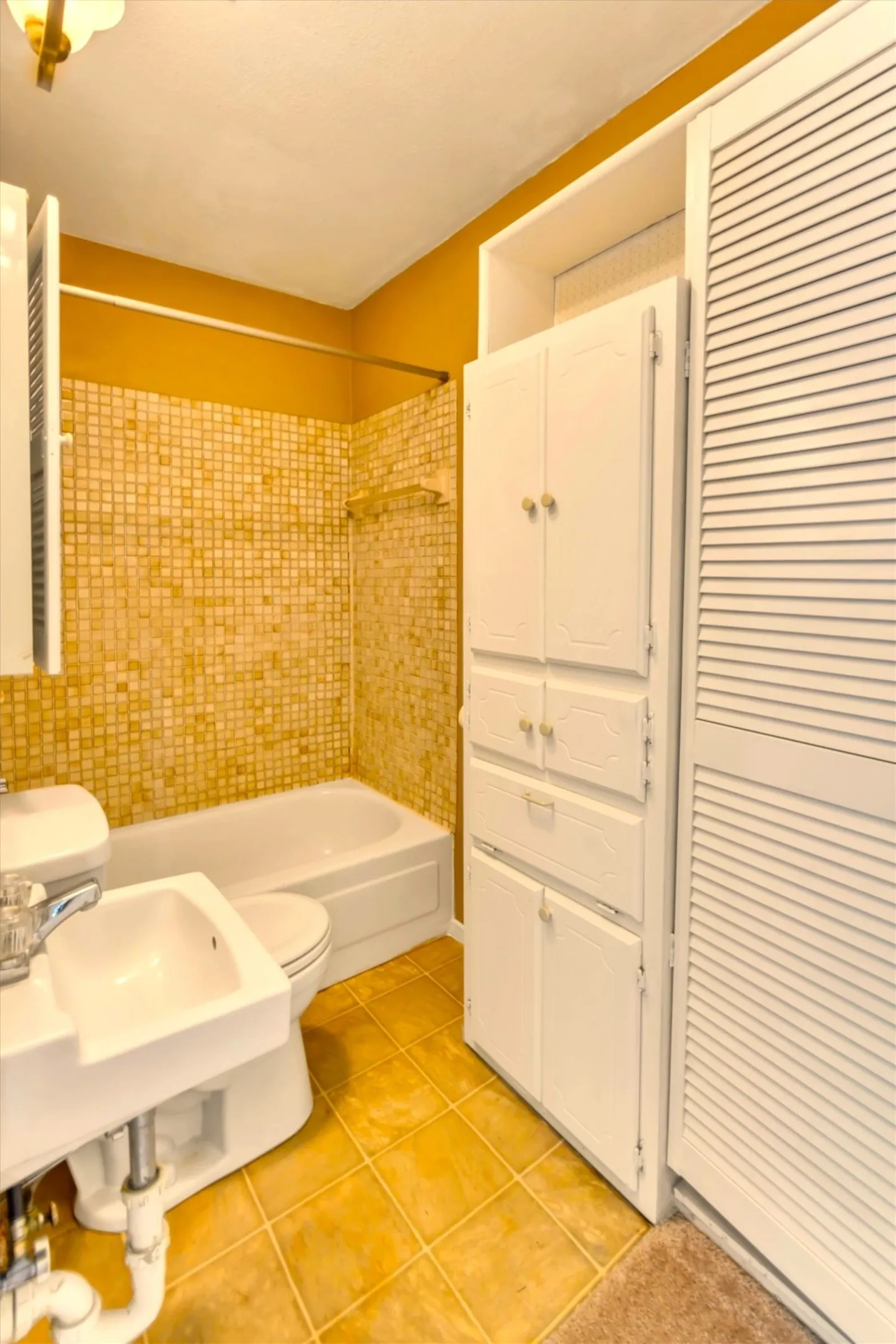 Bathroom featuring a white bathtub, ceramic tile shower surround, square tile flooring, and integrated built-in storage cabinetry