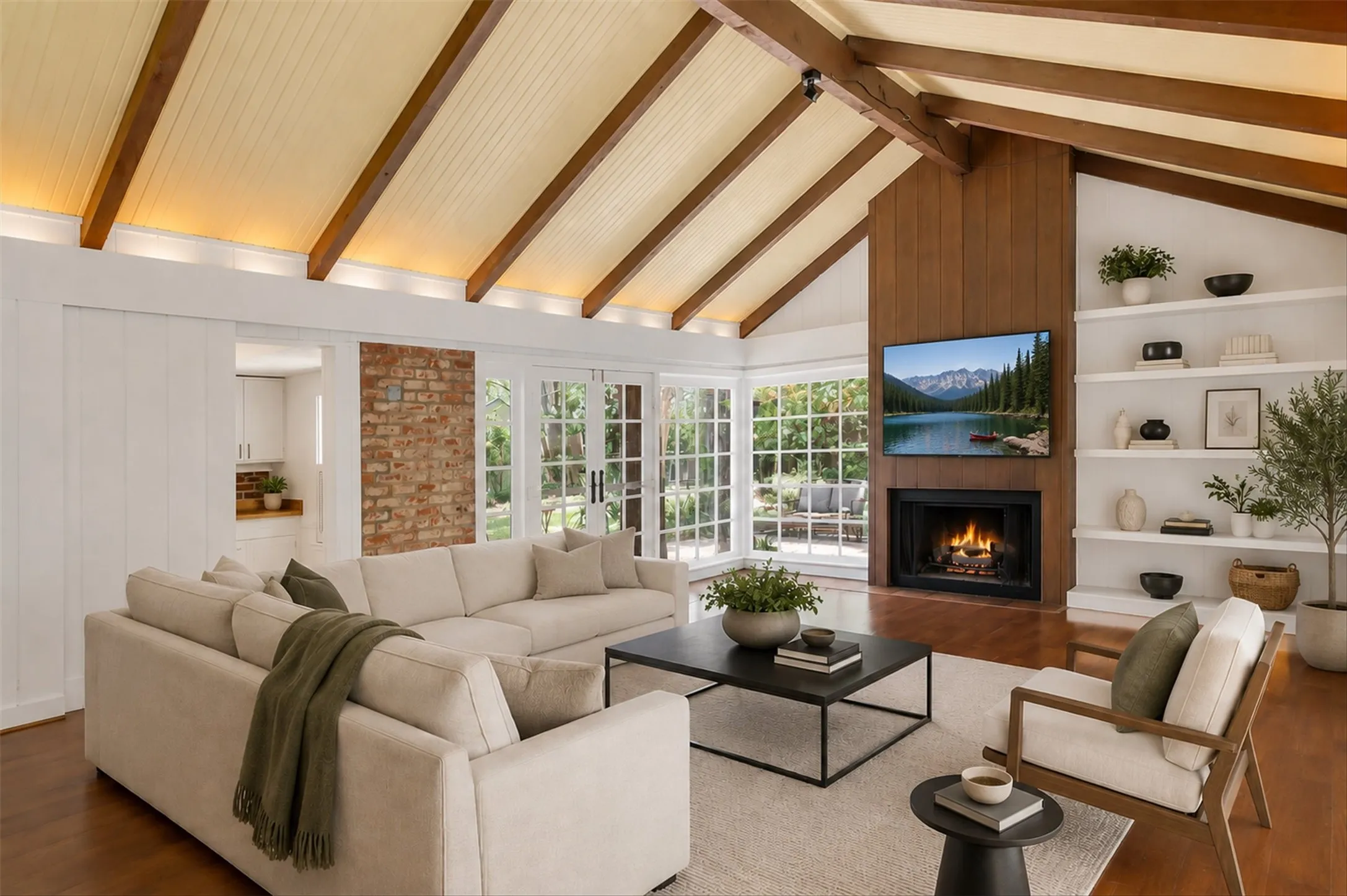 Spacious living area featuring a vaulted ceiling with exposed wood beams, a fireplace with a wood-paneled surround, built-in shelving, and multiple French doors