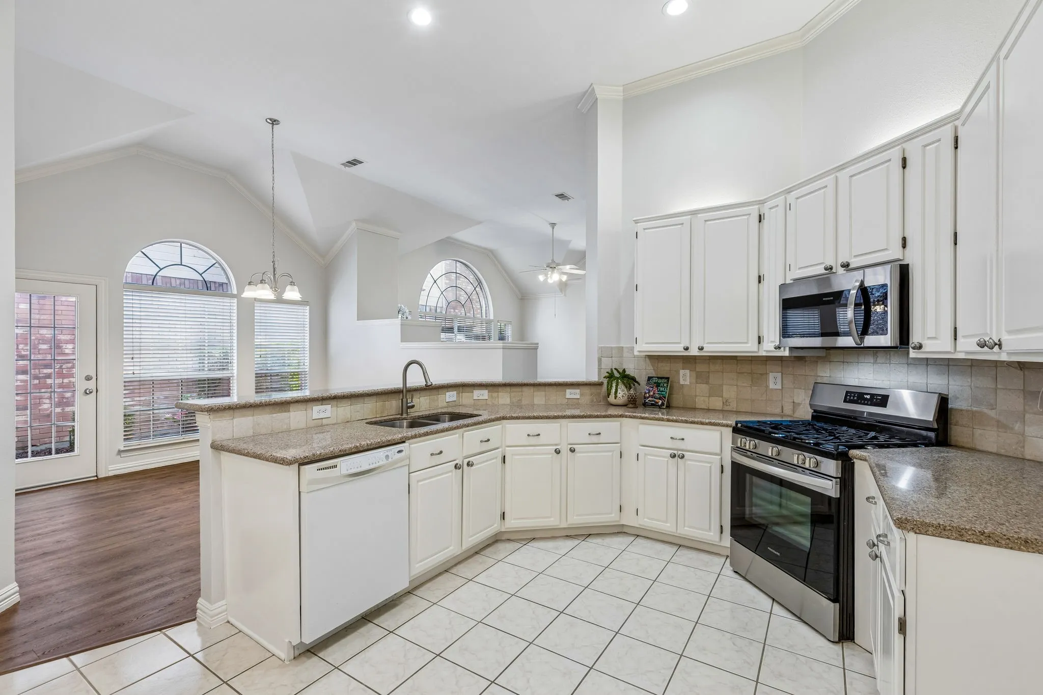 Kitchen featuring white cabinetry, granite countertops, stainless steel appliances, and tile flooring