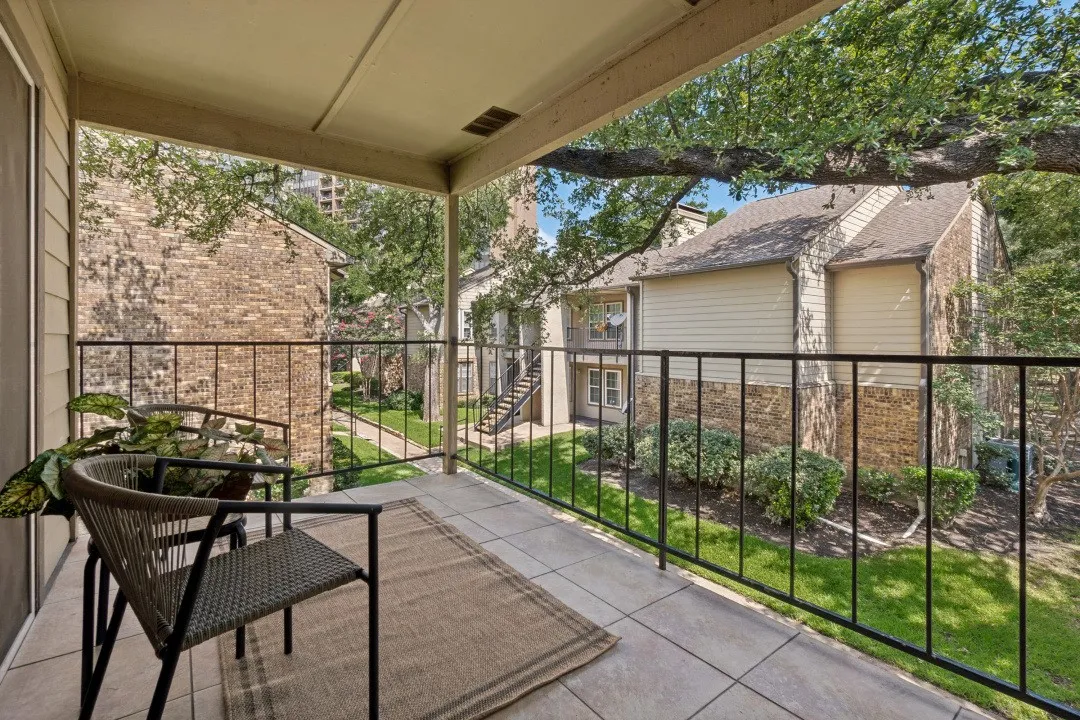 Covered balcony with tile flooring and a black metal railing