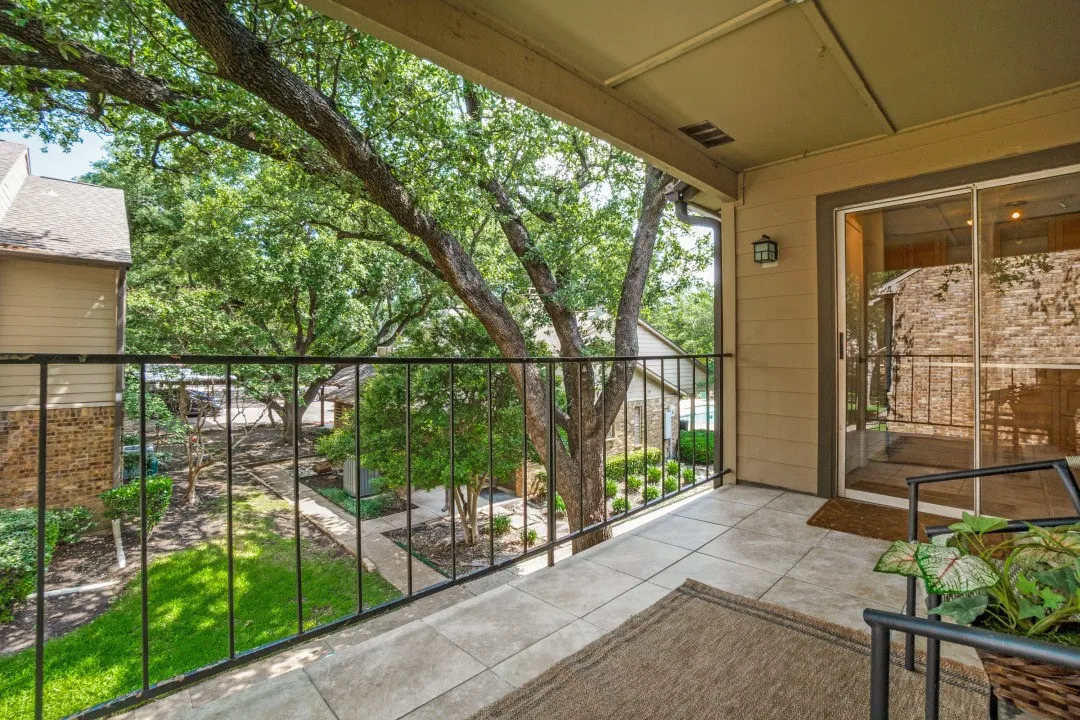 Covered balcony featuring tile flooring and a black metal railing