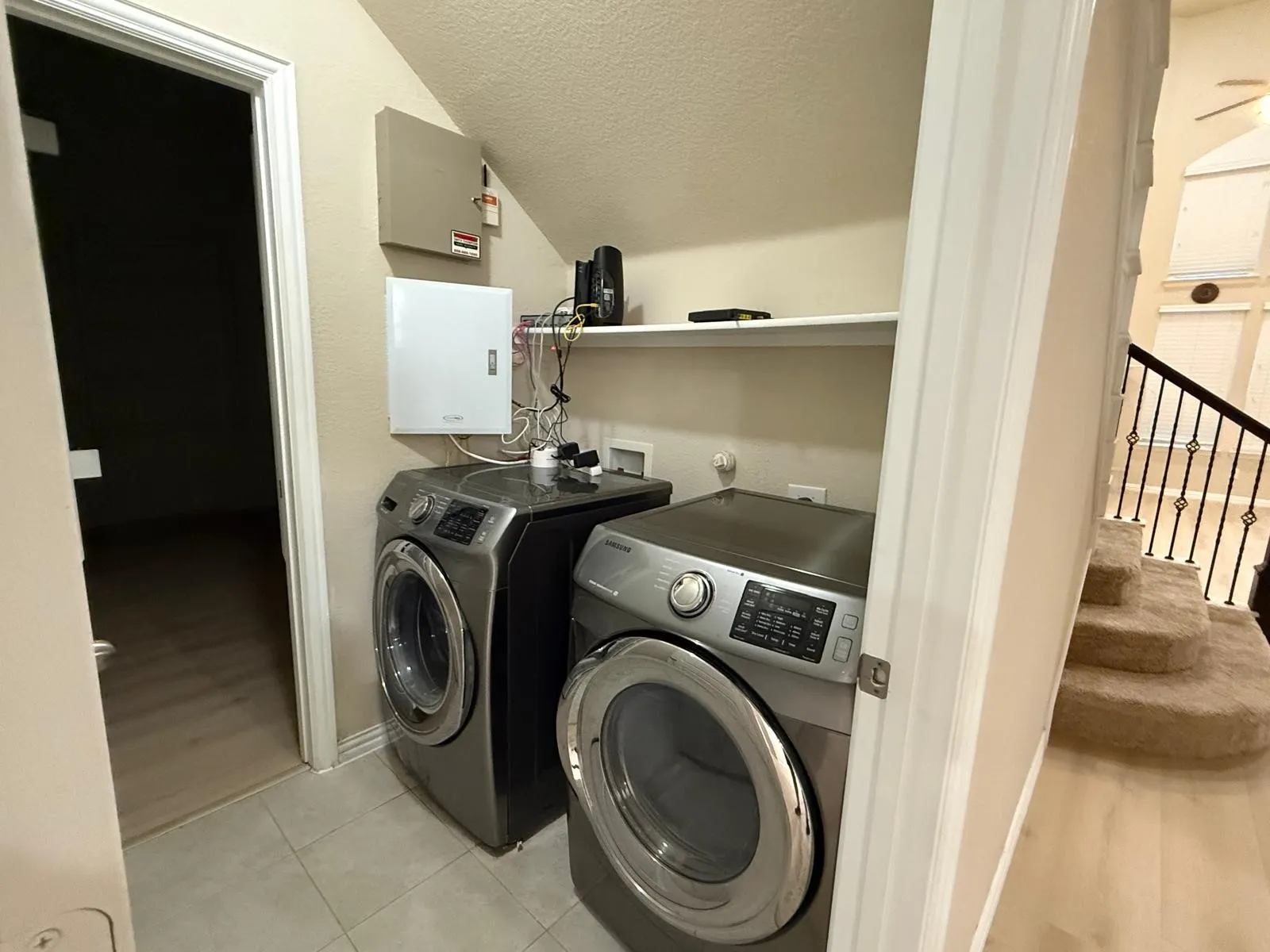 Dedicated laundry area featuring a white utility shelf and neutral wall color