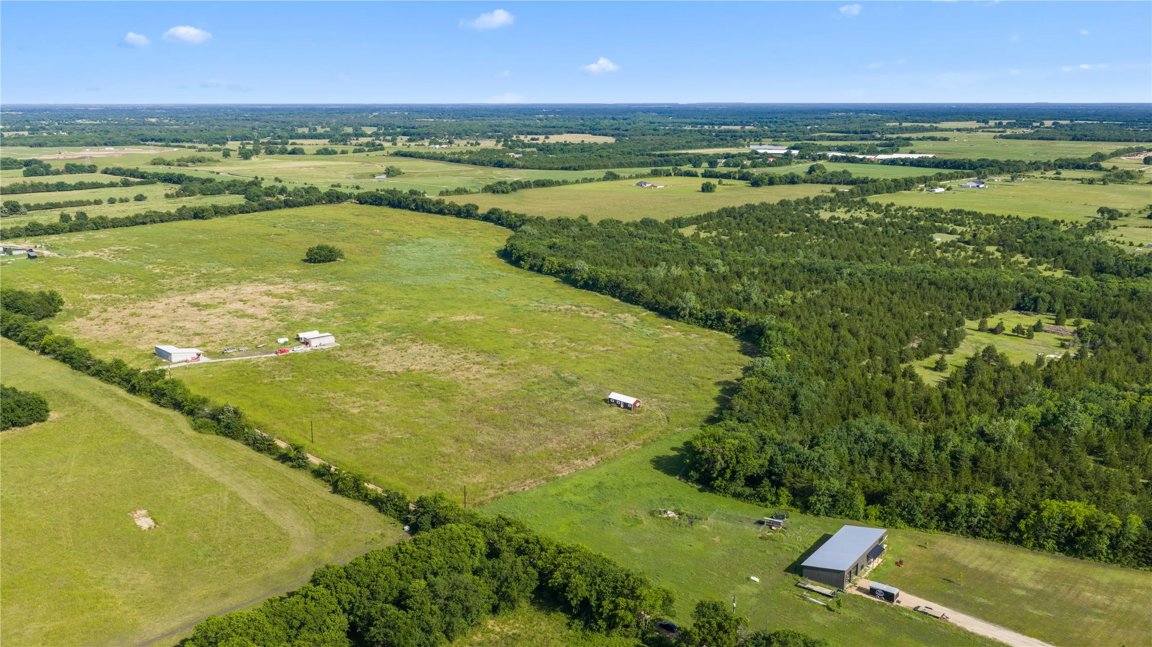 Expansive property featuring a blend of open pastures and dense wooded areas