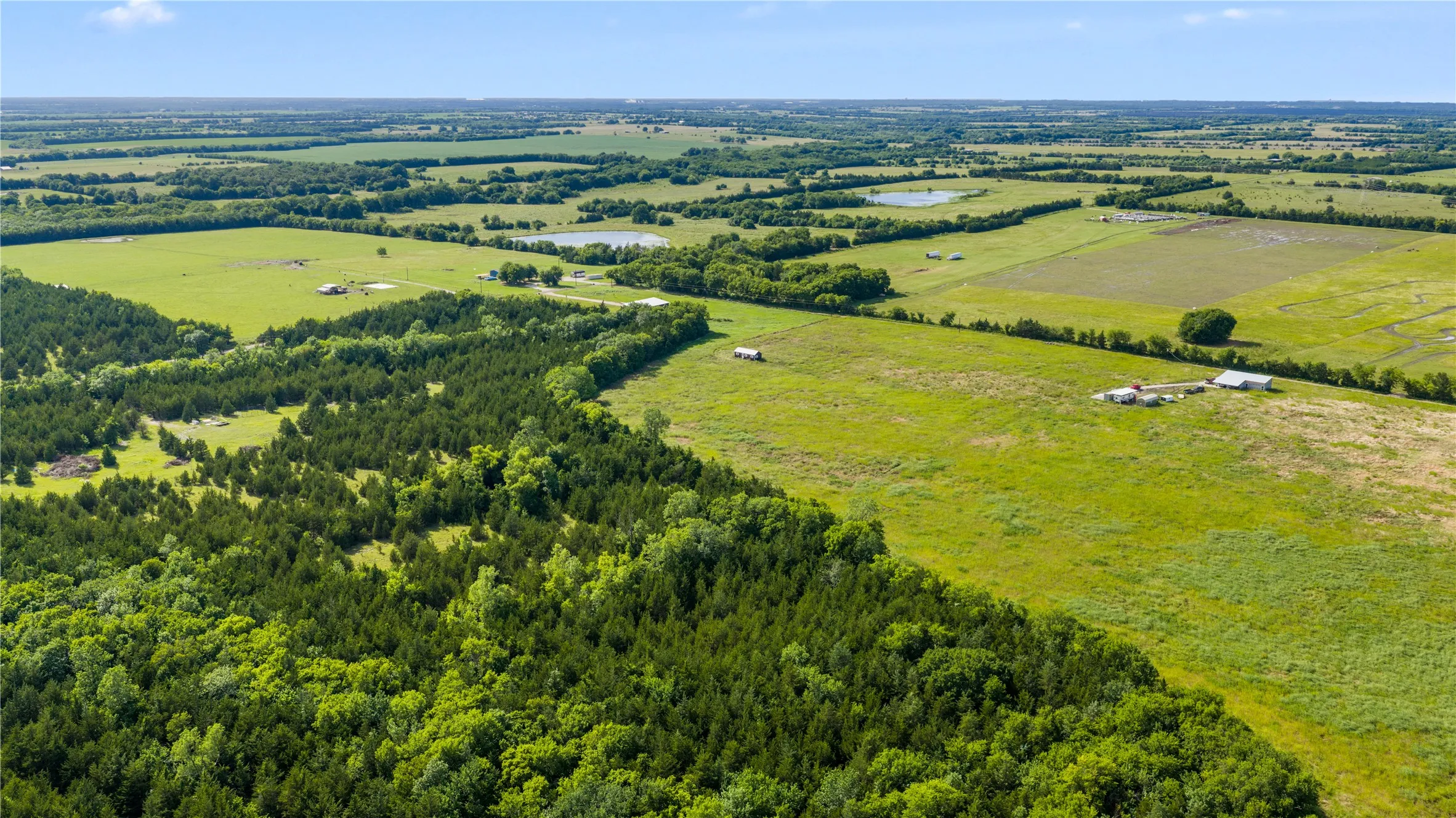 Expansive land parcel featuring a mix of dense tree coverage and open grassy fields